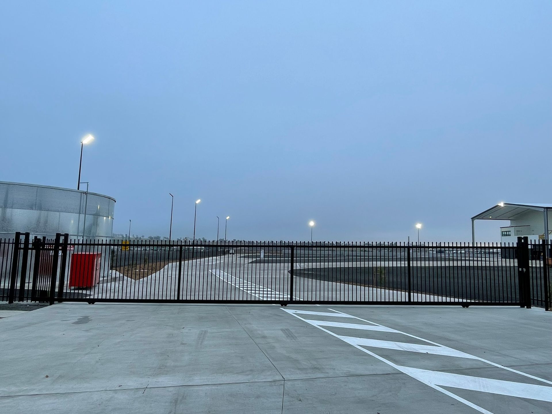 A sliding gate in a parking lot with a blue sky in the background