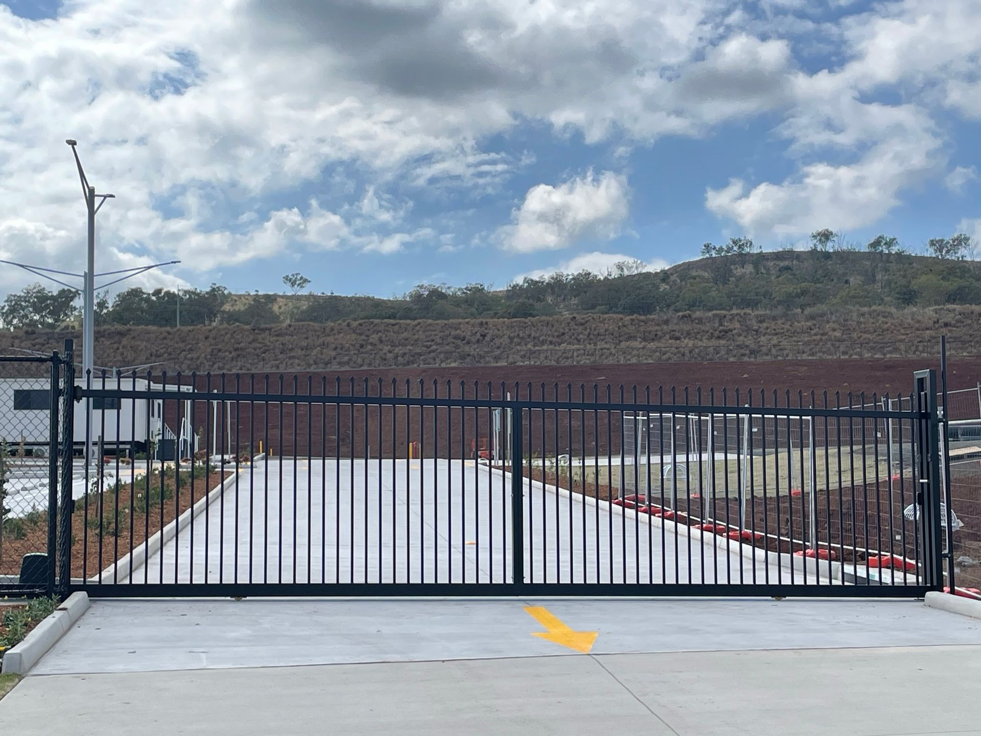 A sliding gate with a brick wall in the background