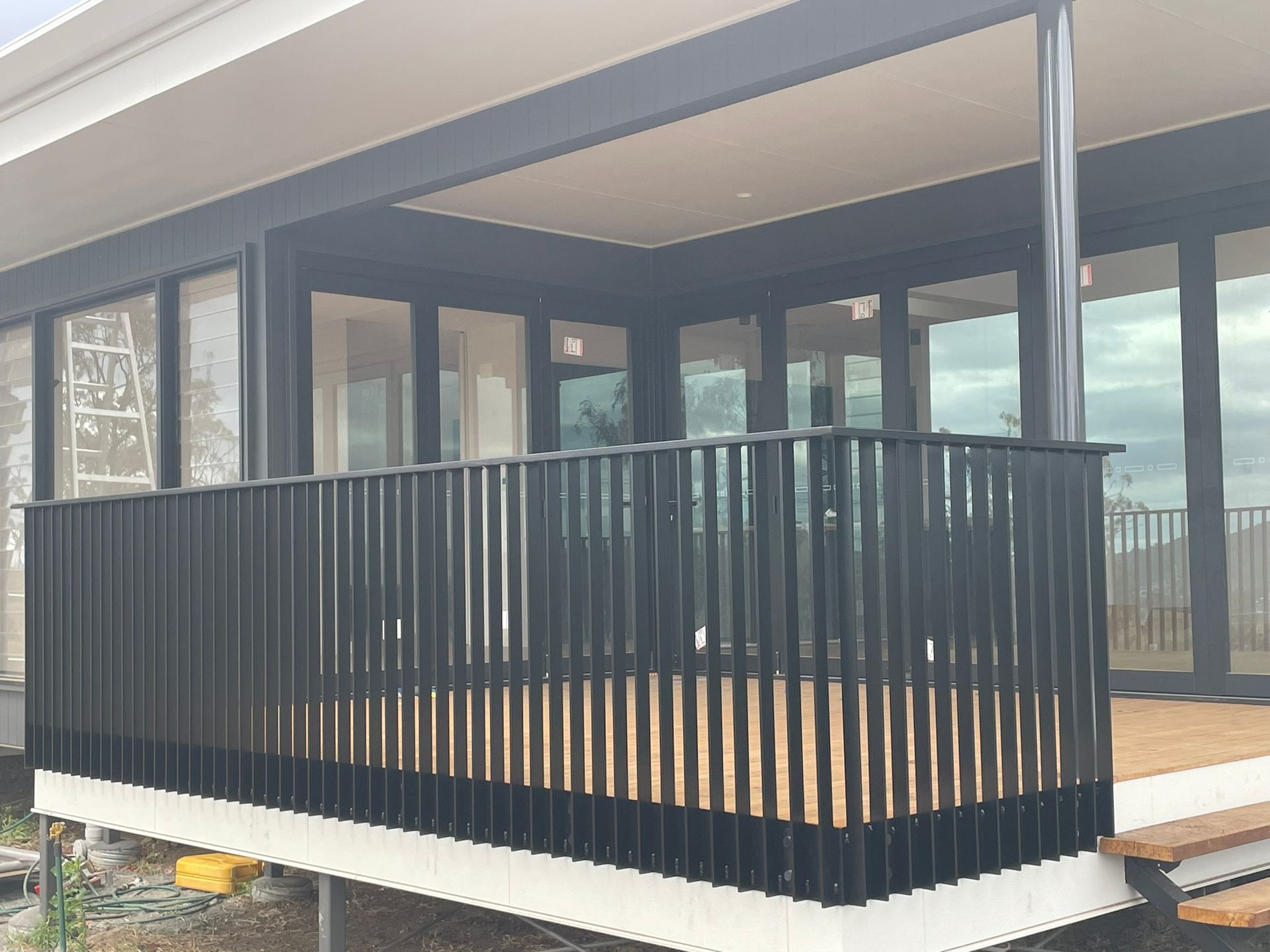 A balcony with a black railing on the side of a house.