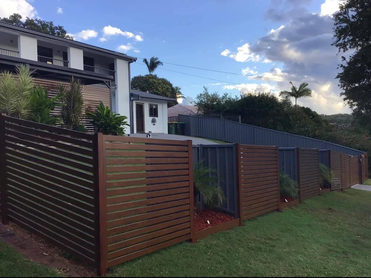 A house with a custom metal fence in front of it