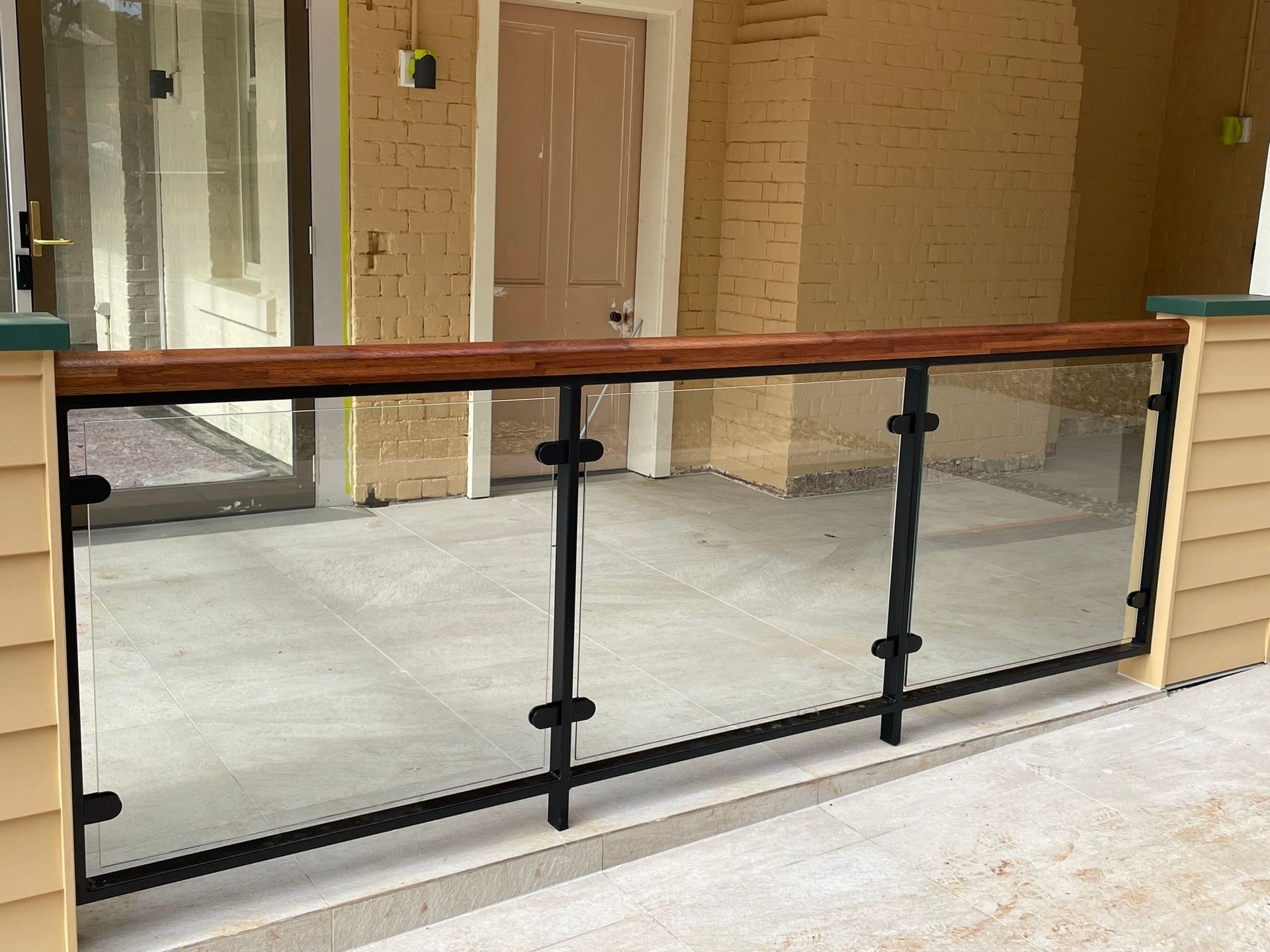 A balcony with a glass railing and a wooden railing