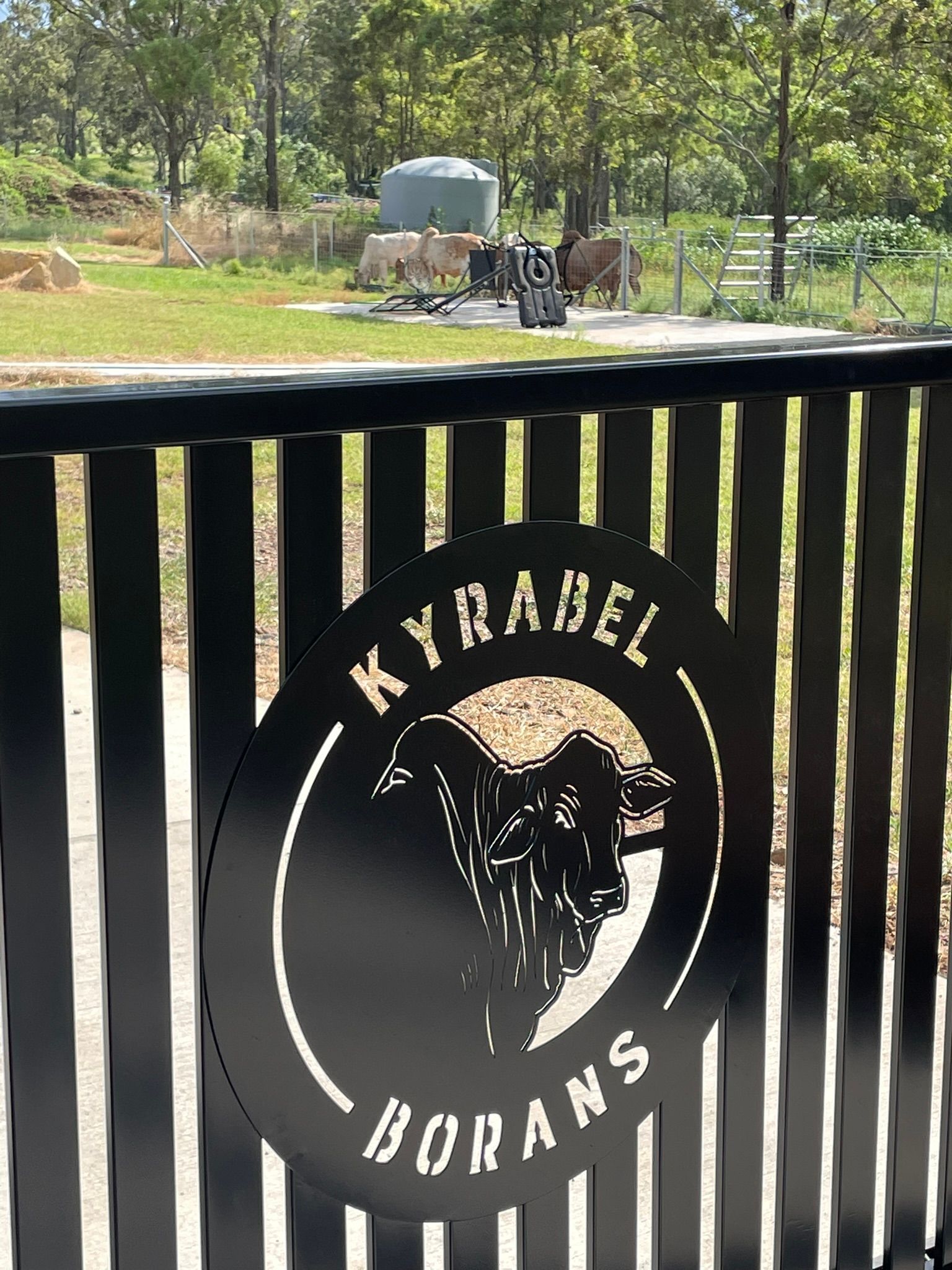 A black fence with a laser cut sign on it that says kyrabel borans.