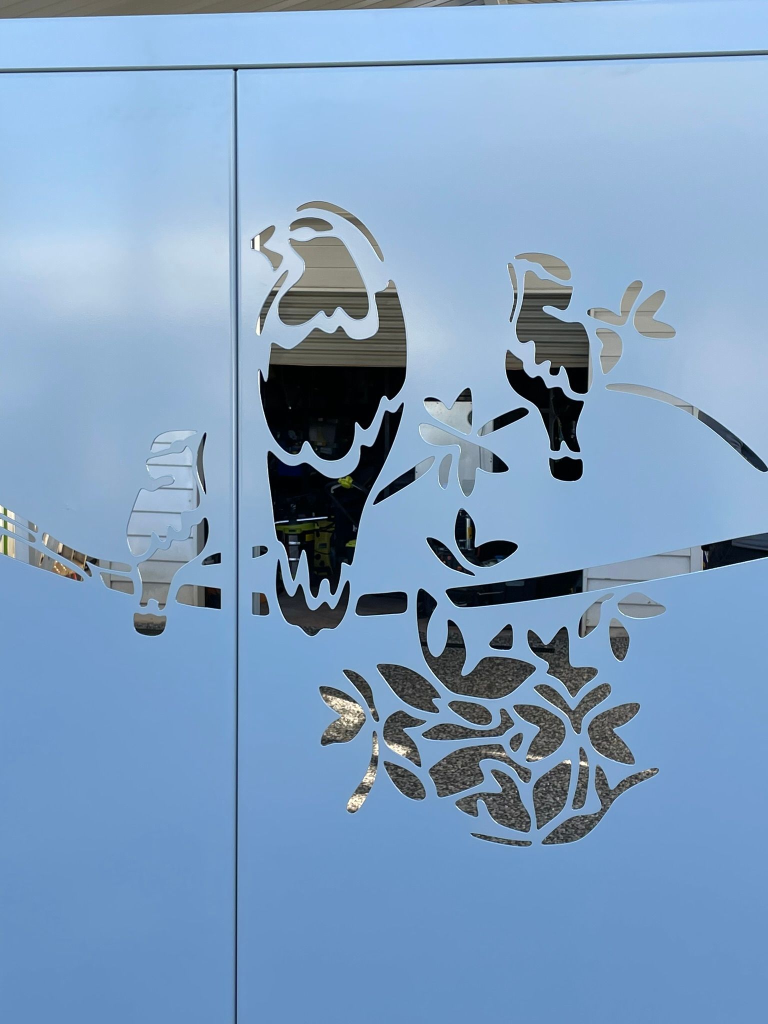 A laser cut image of two birds sitting on a tree branch