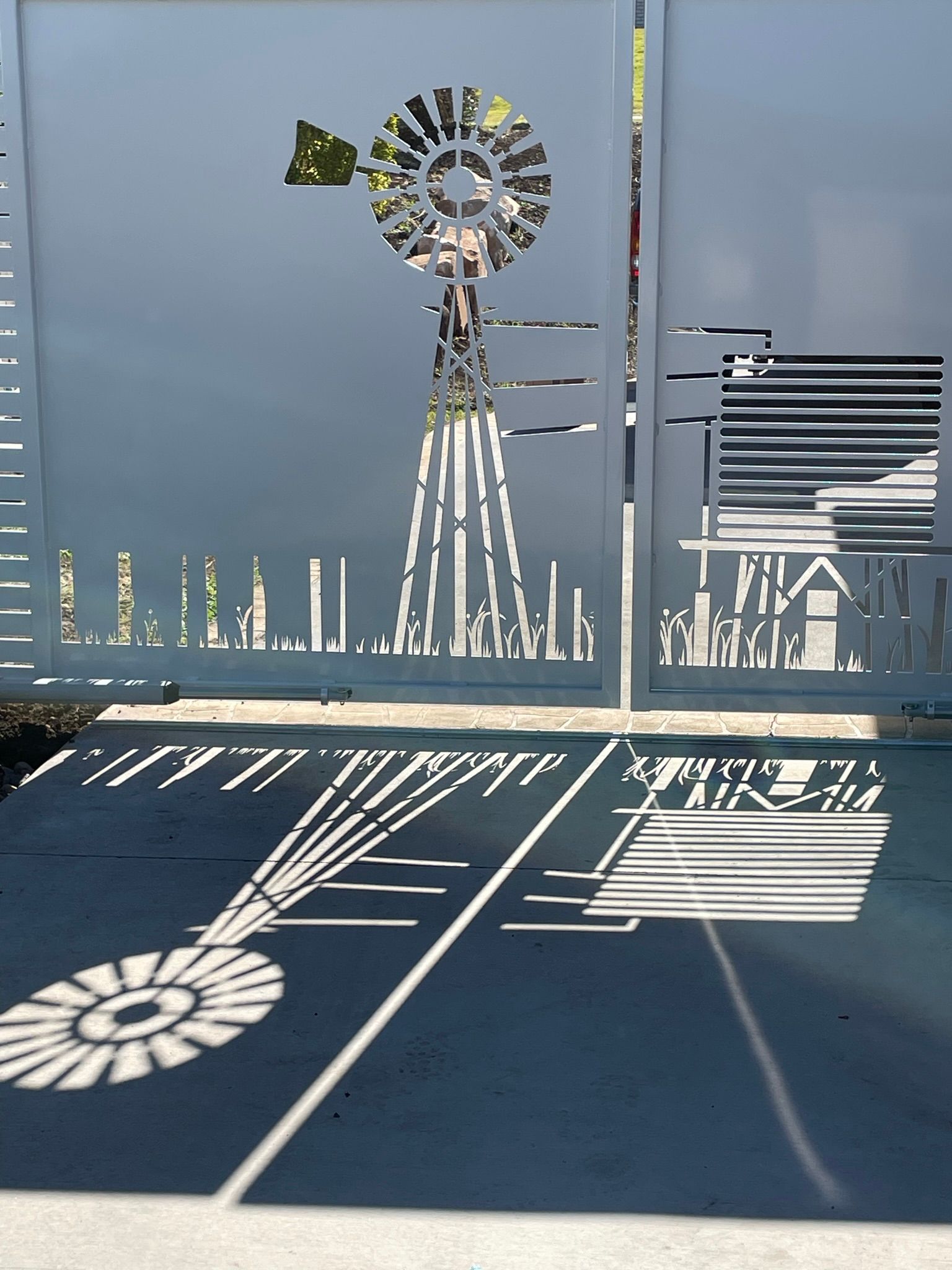 A metal fence with a laser cut image of a windmill on it