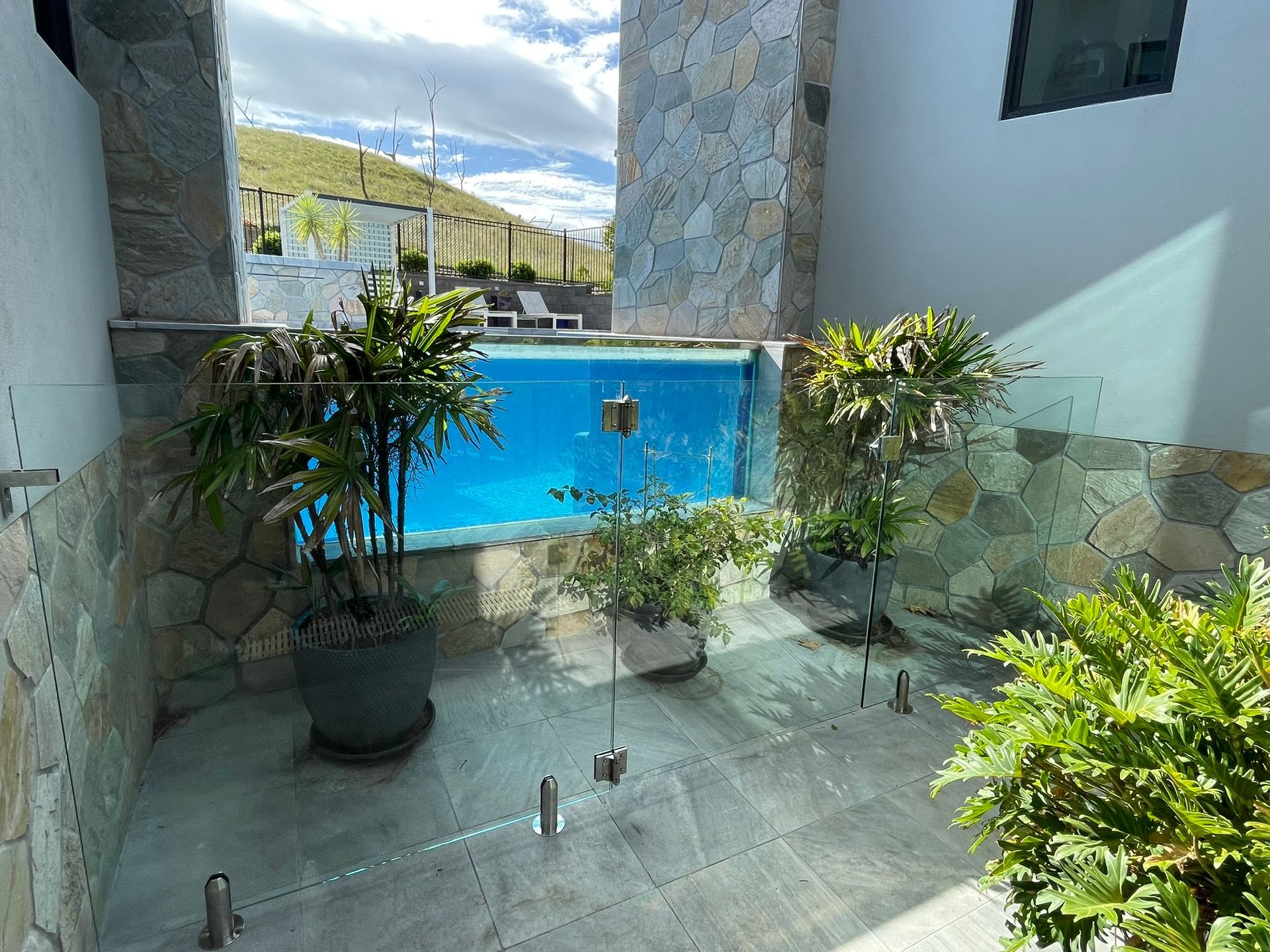 There is a swimming pool in the backyard of a house.