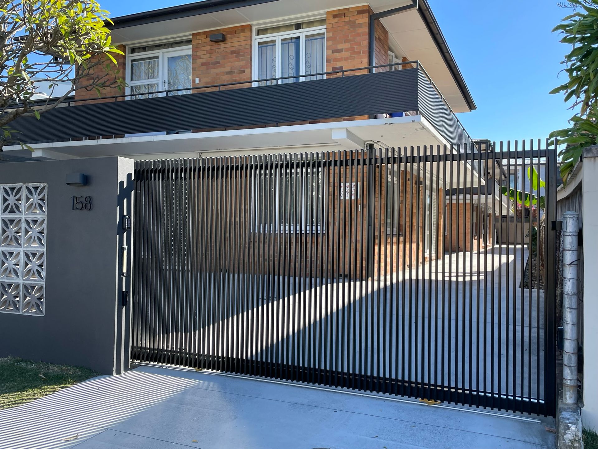 A house with a sliding gate in front of it.