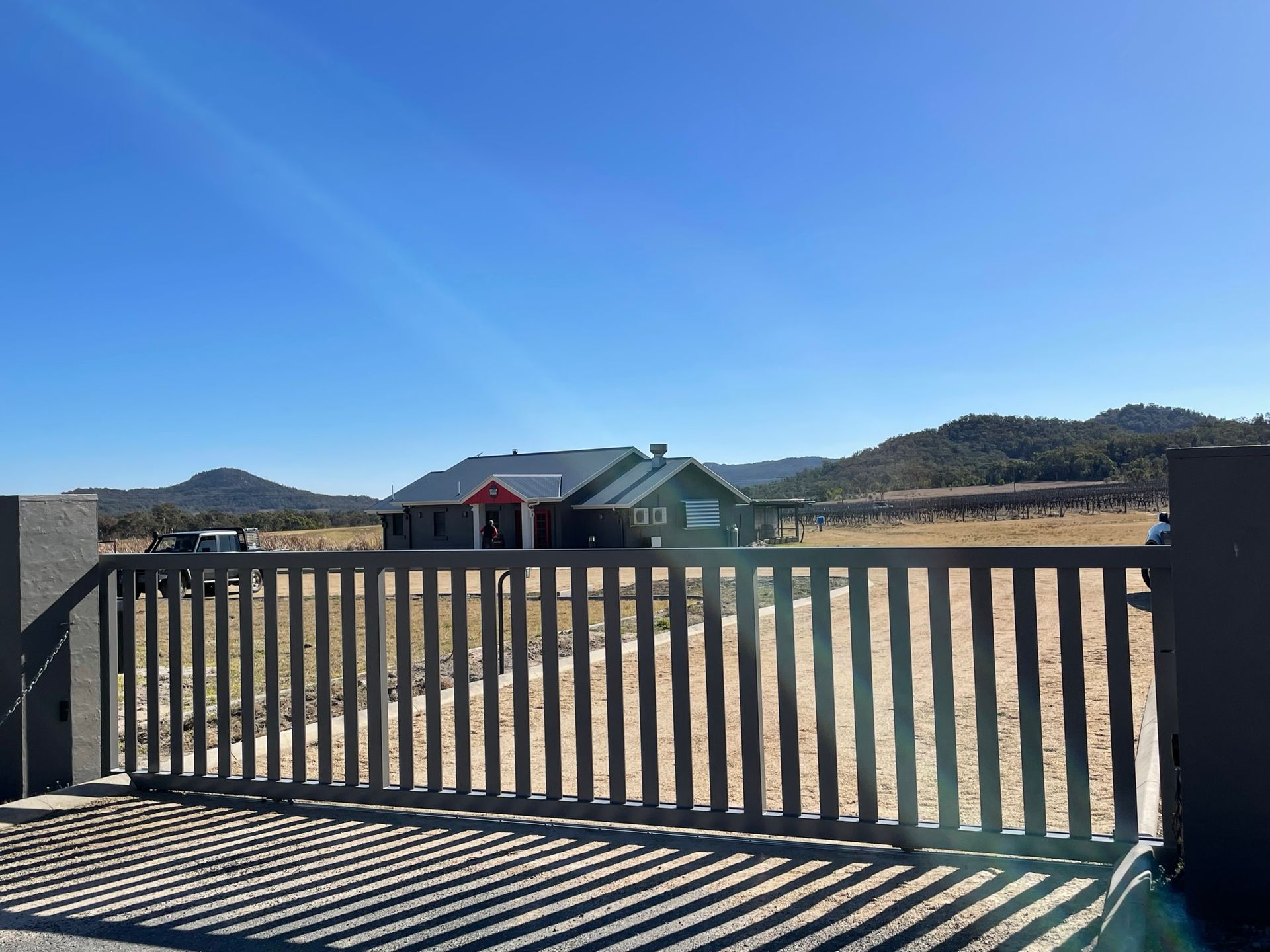 A sliding gate with a house in the background