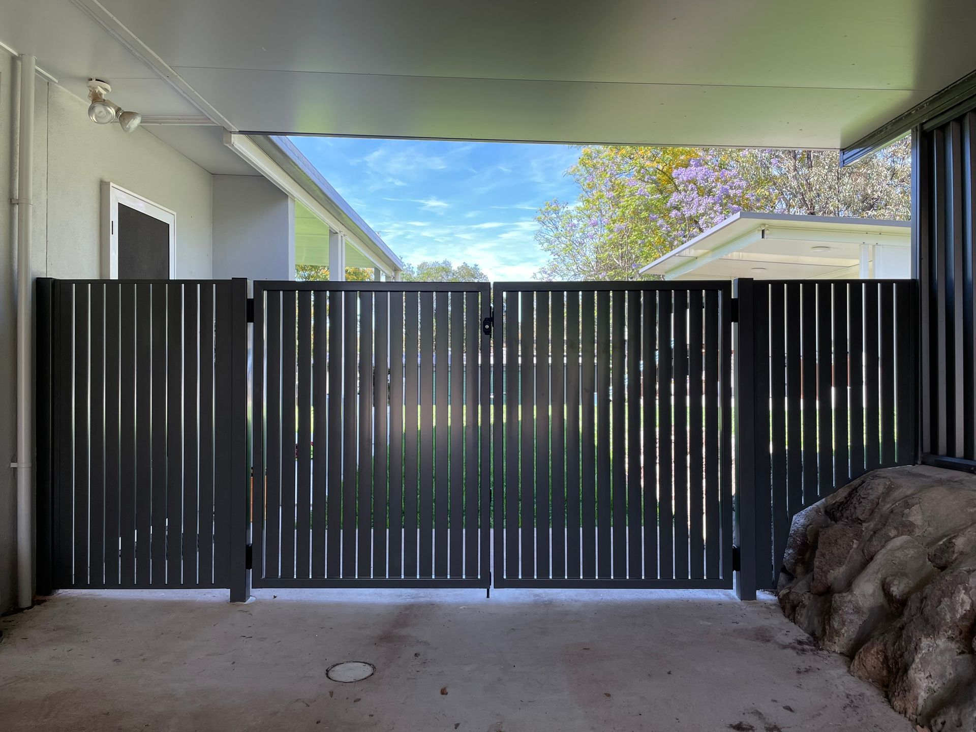 A black fence is sitting in front of a house.