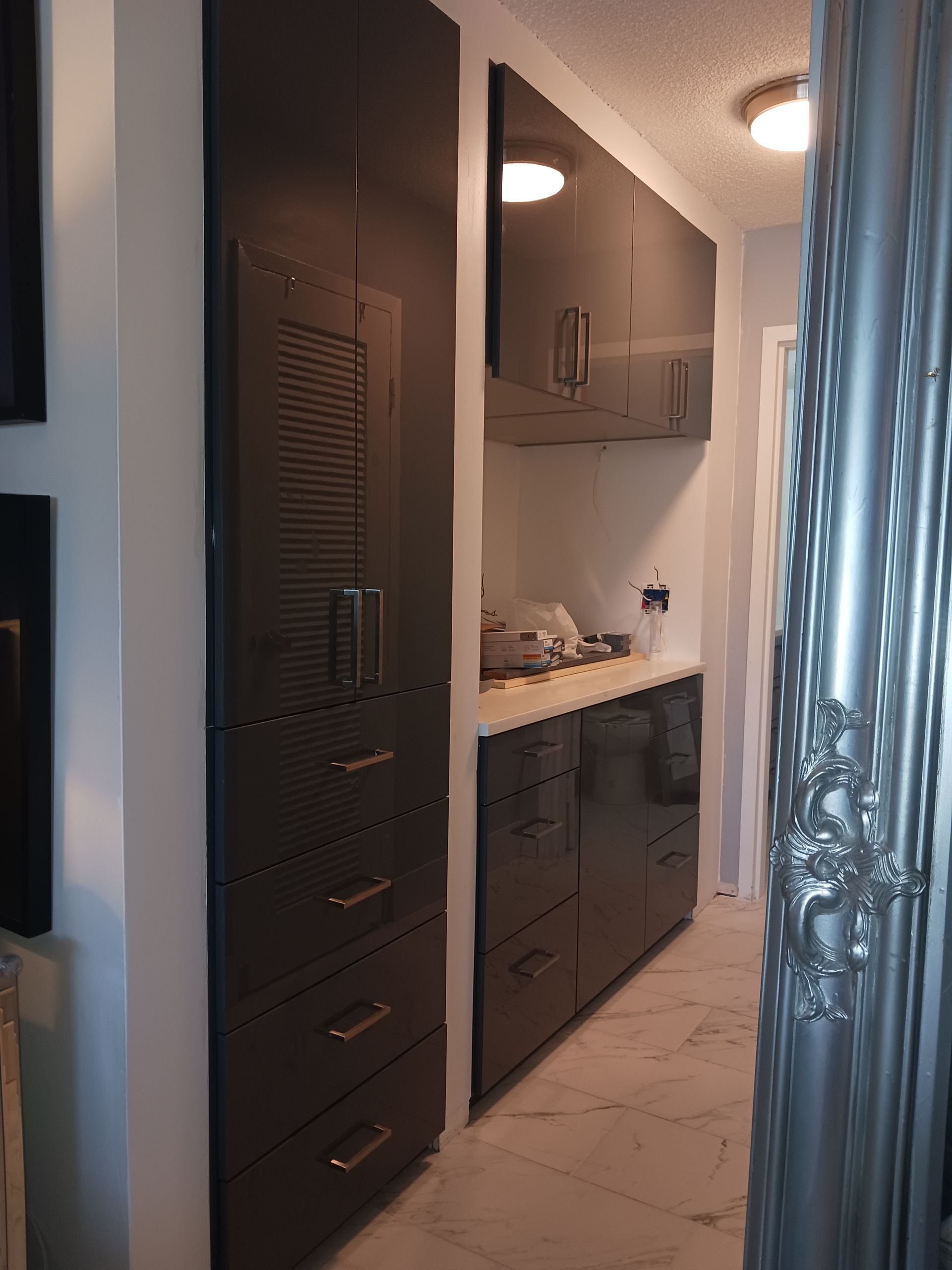 A kitchen with lots of black cabinets and drawers