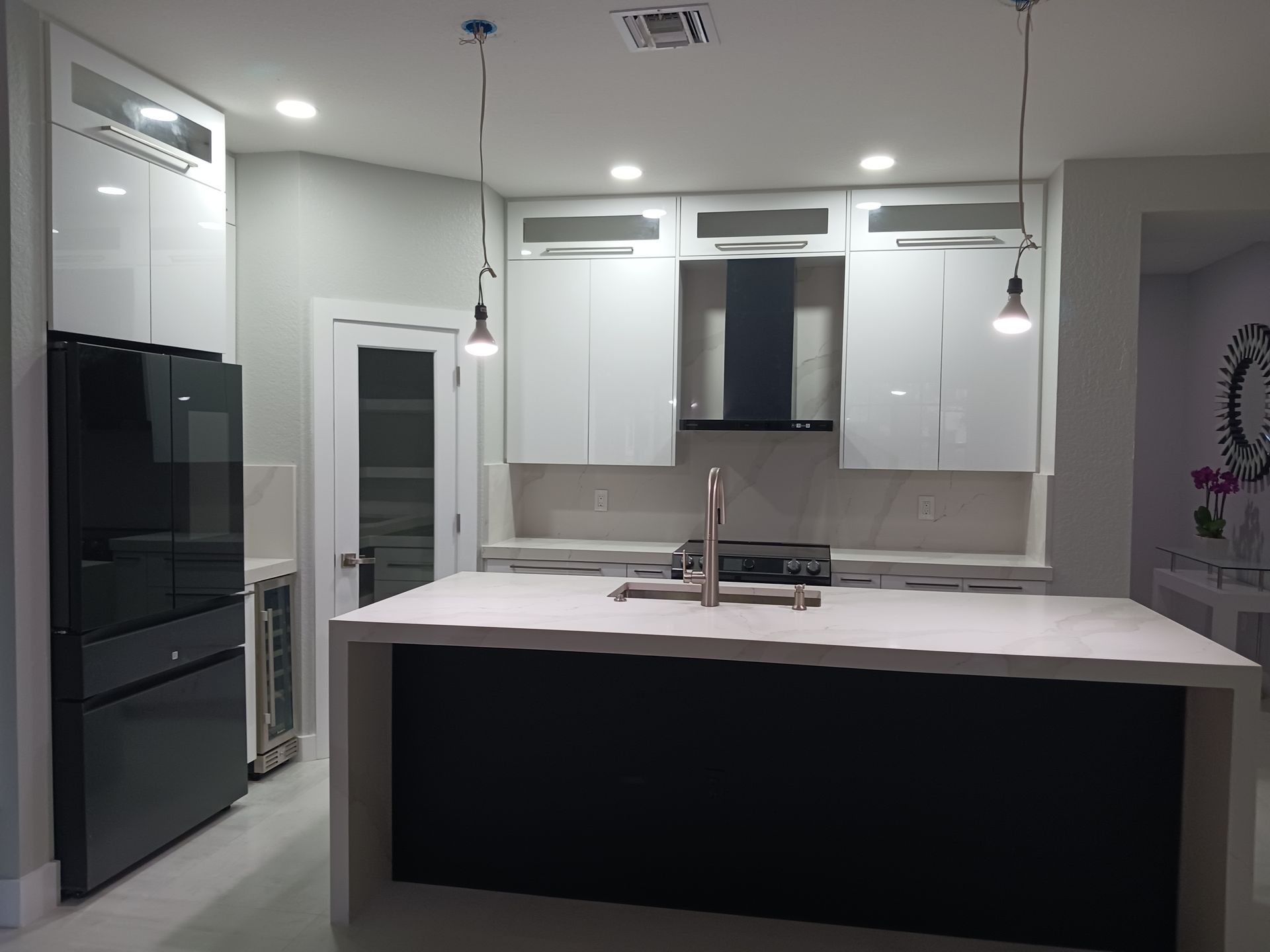 A kitchen with lots of black cabinets and drawers