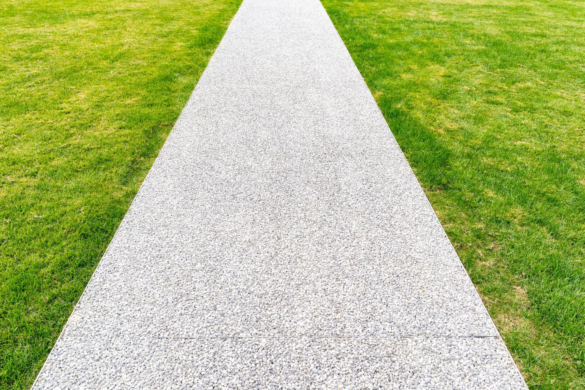 A white path going through a grassy field