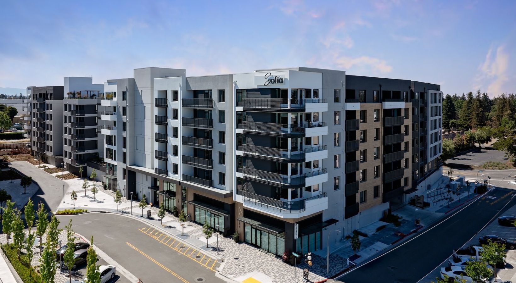 Exterior view of a modern apartment building with multiple balconies along a curved façade at Sofia.