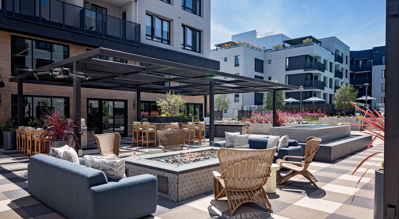 Outdoor lounge with cushioned seating, planters, and a water feature at Sofia, offers apartments for rent in Santa Clara, CA.