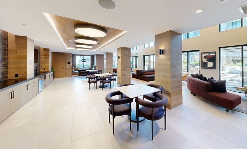 Interior common area with seating, tables, and a kitchenette in a modern apartment community at Sofia, offers  pet-friendly apartments in Santa Clara.