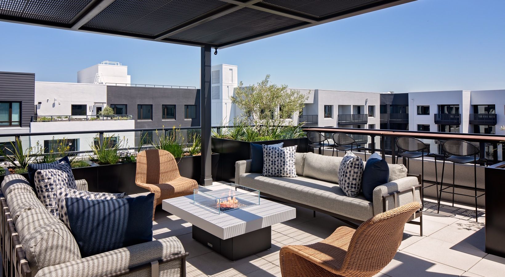 Outdoor apartment balcony with modern seating and a fire table at Sofia.