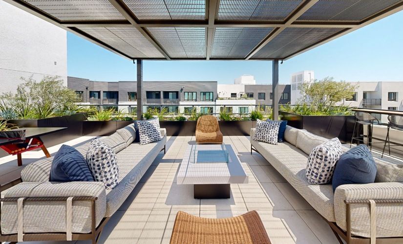 Outdoor rooftop lounge with sectional seating, cushions, and a shaded canopy at Sofia, offers  pet-friendly apartments in Santa Clara.