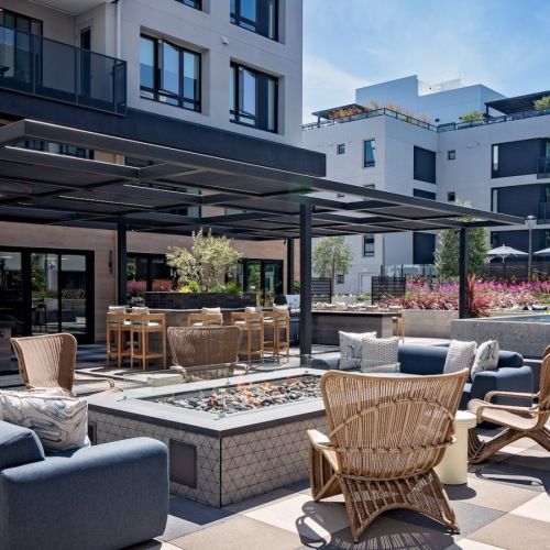 Outdoor community lounge on a rooftop terrace with seating and a fire pit under a pergola at Sofia, offers  pet-friendly apartments in Santa Clara.