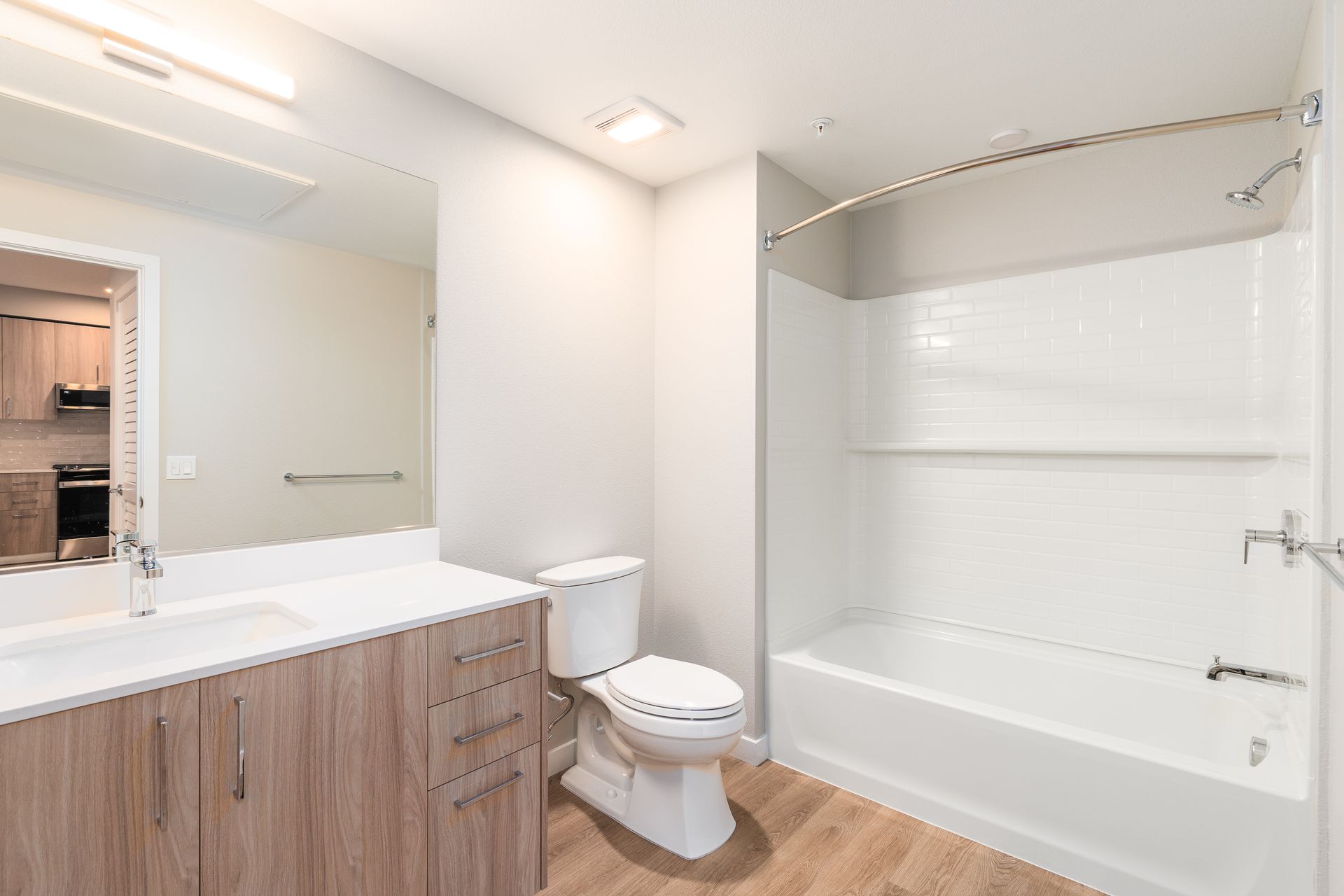Bathroom with white bathtub, toilet, and vanity with light wood cabinets at Sofia, offers studio, 1, and 2 bedroom apartments in Santa Clara, CA.