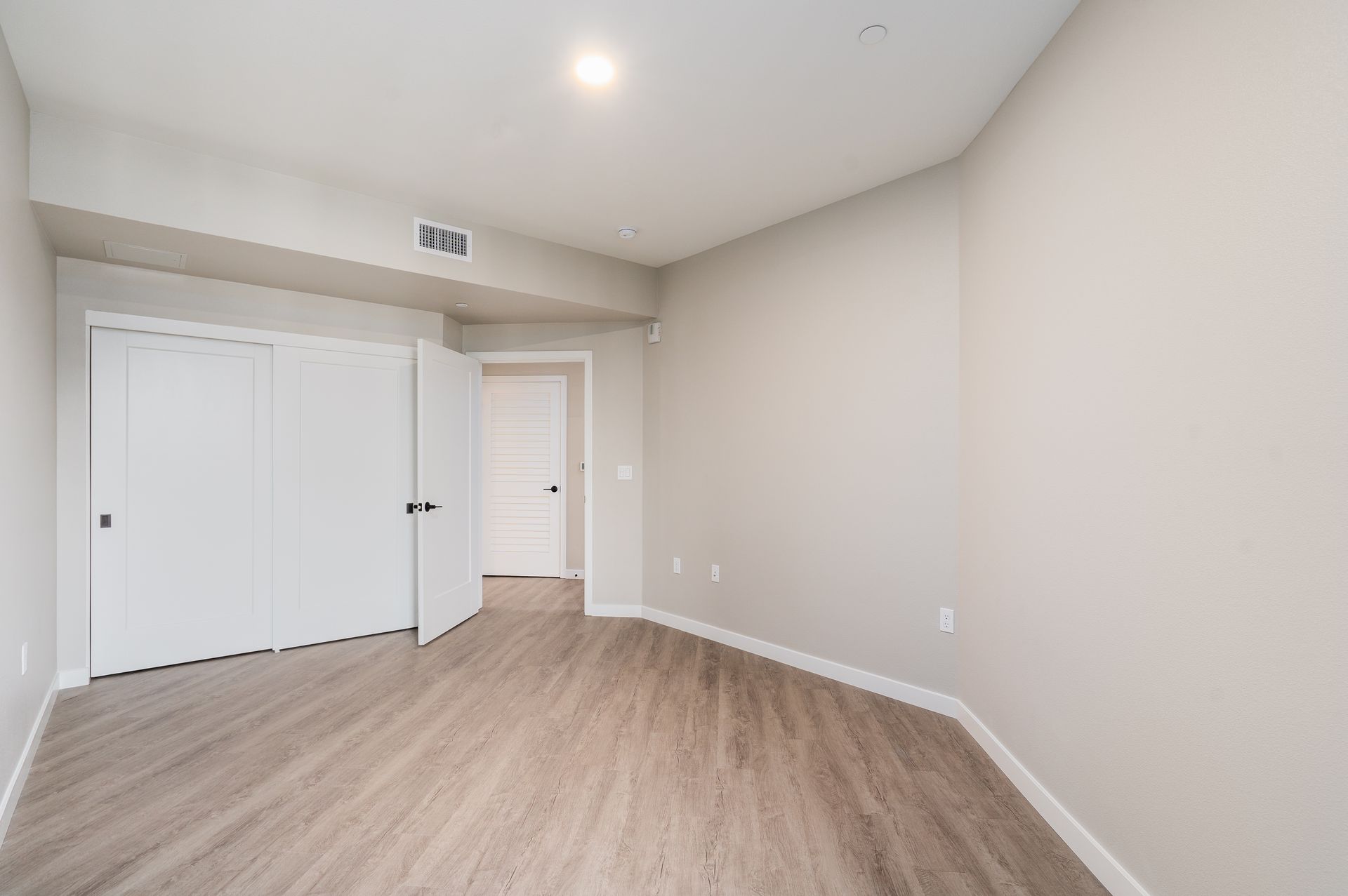 Empty room with closet and door at Sofia, offers apartments in Santa Clara. Light gray walls, light wood-look floor.
