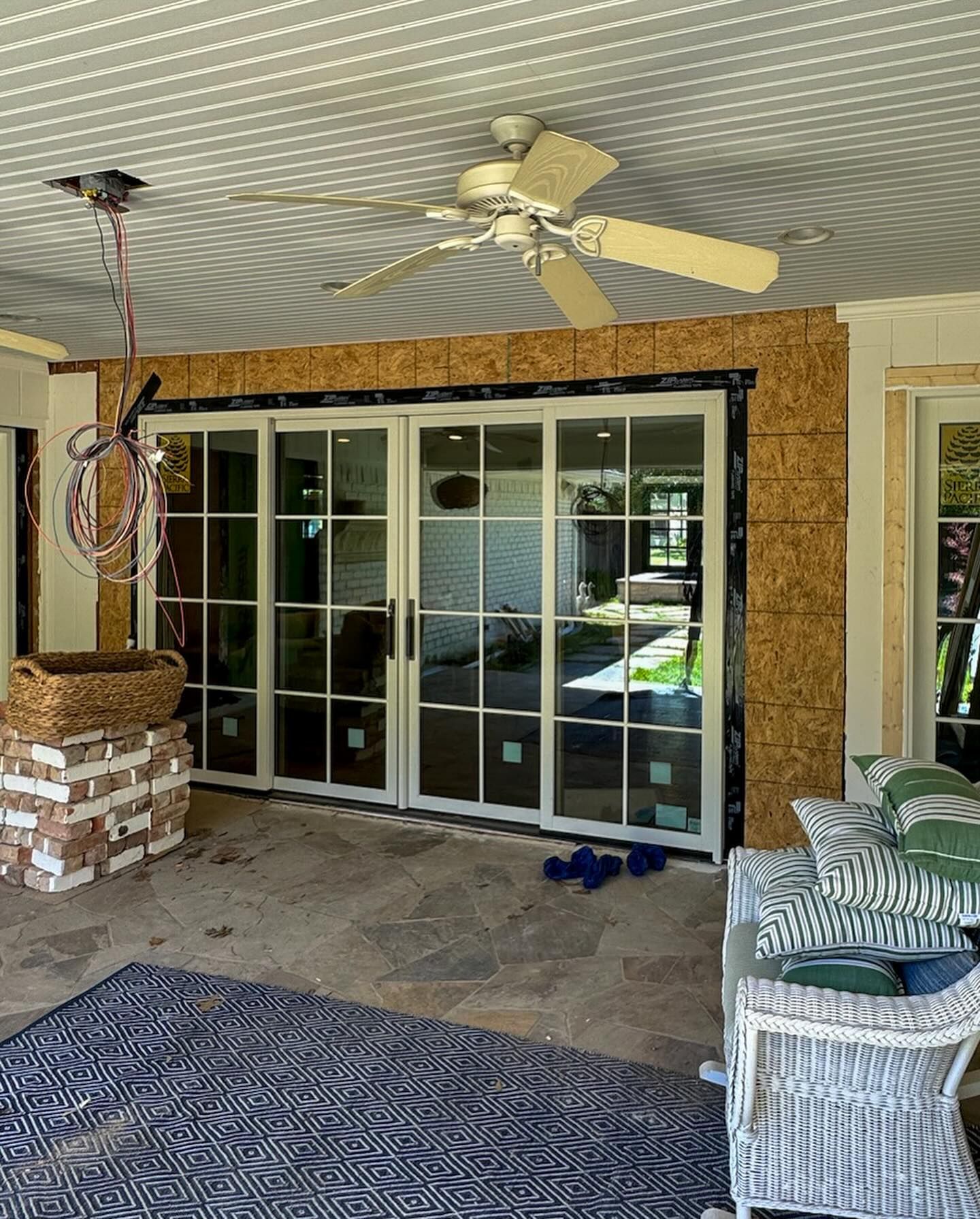 A patio with sliding glass doors and a ceiling fan.