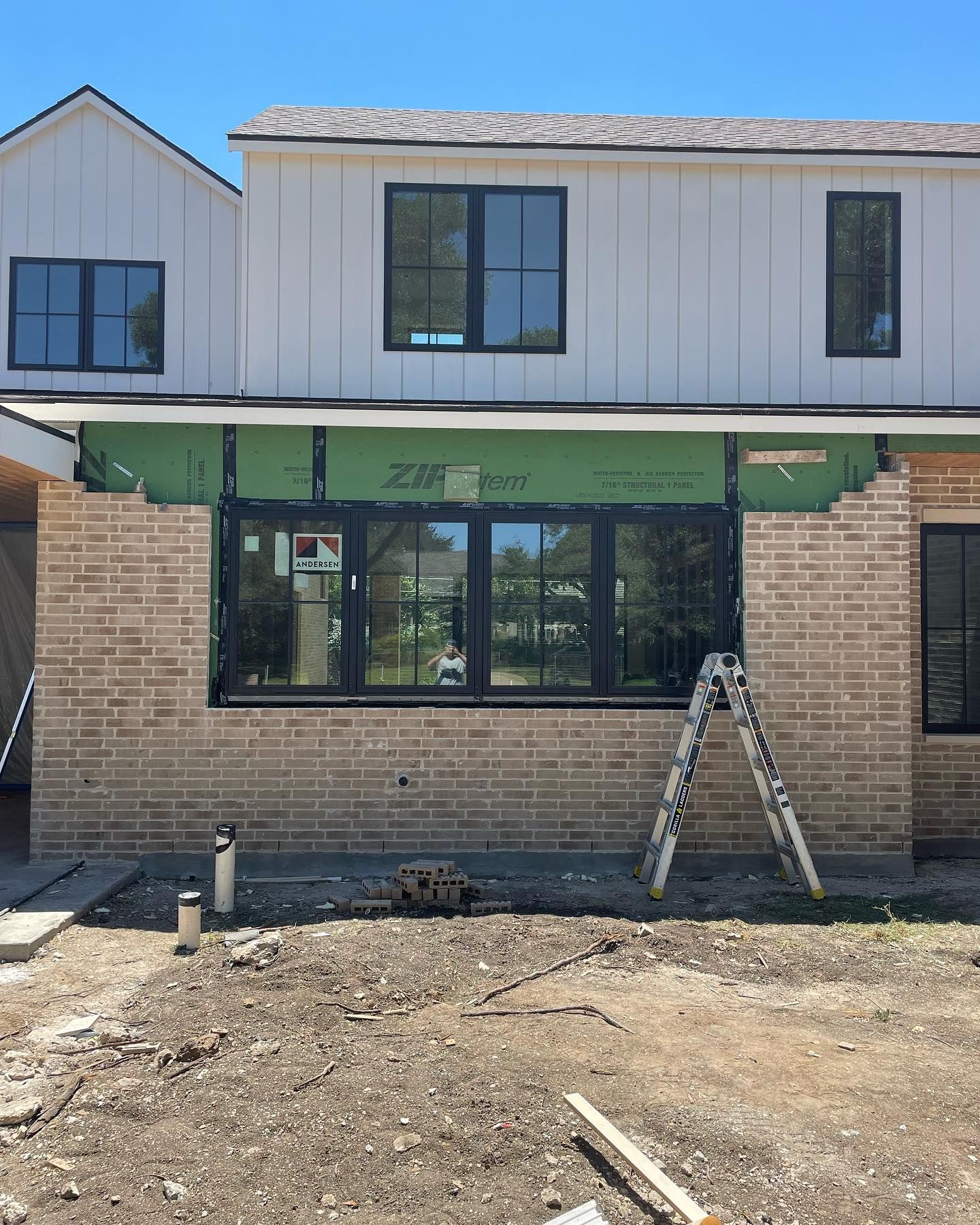 A white house with a lot of windows is being built.