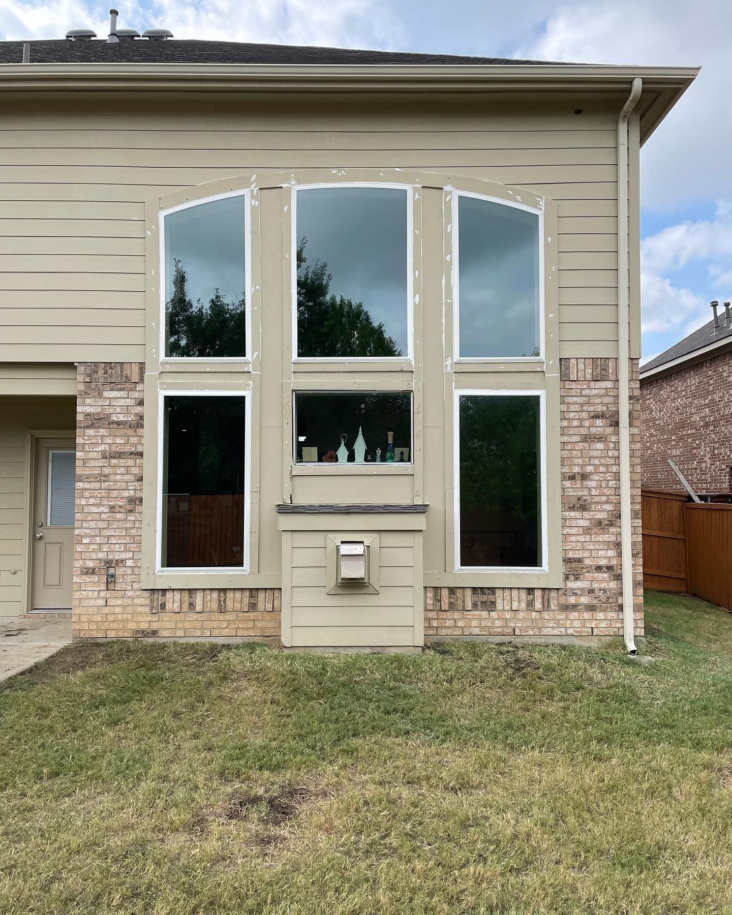 A house with a lot of windows and a mailbox in the backyard.