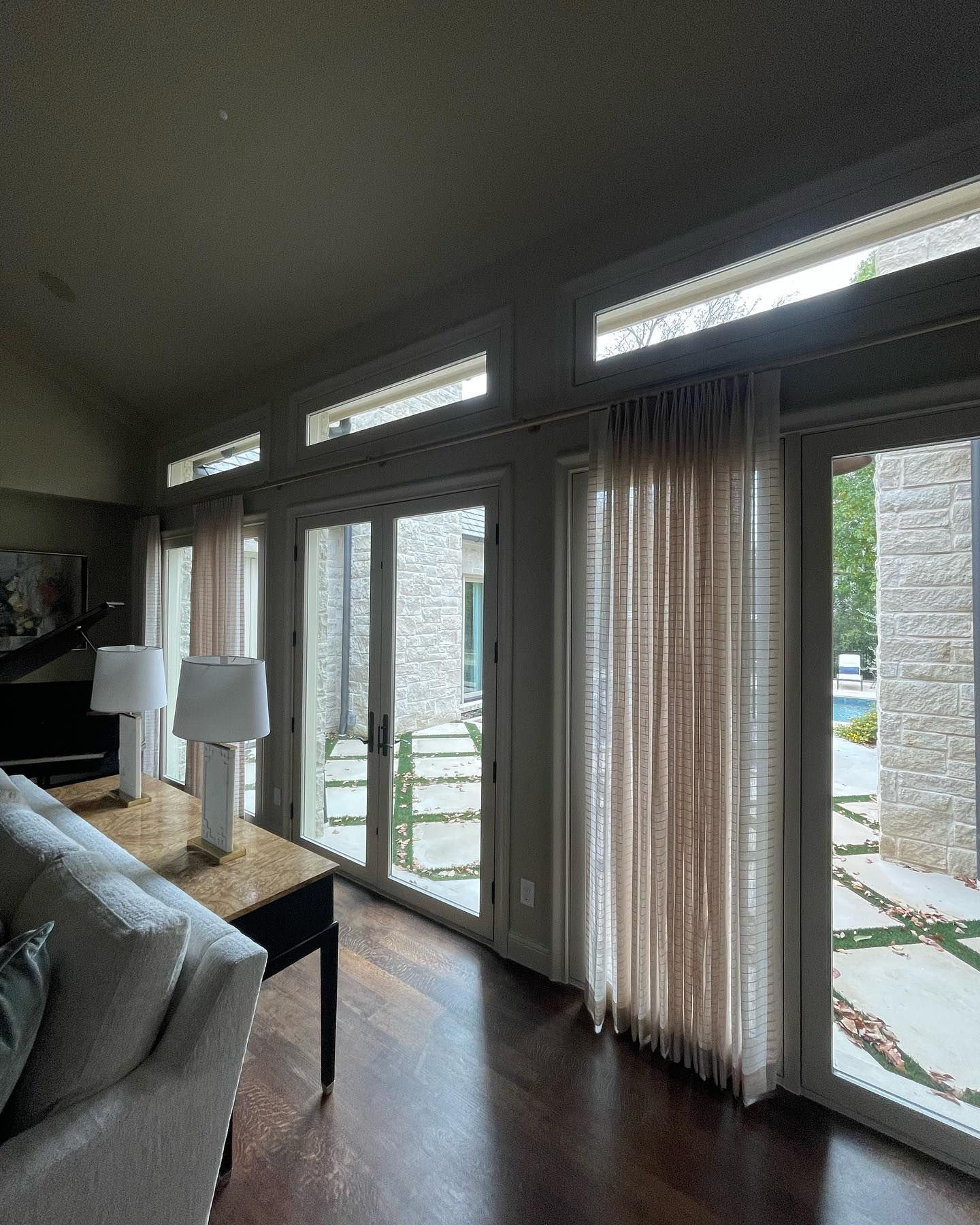 A living room with lots of windows and curtains