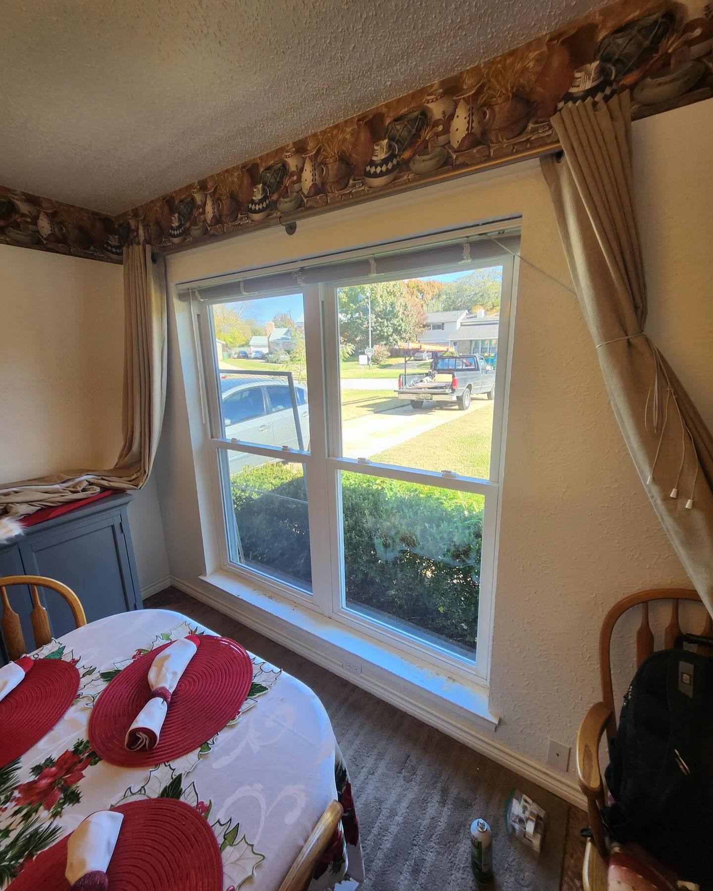 A bedroom with a table and chairs and a large window.