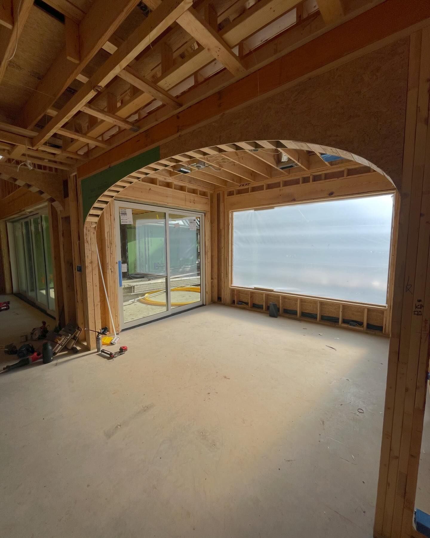 An empty room with a large window and a wooden frame.