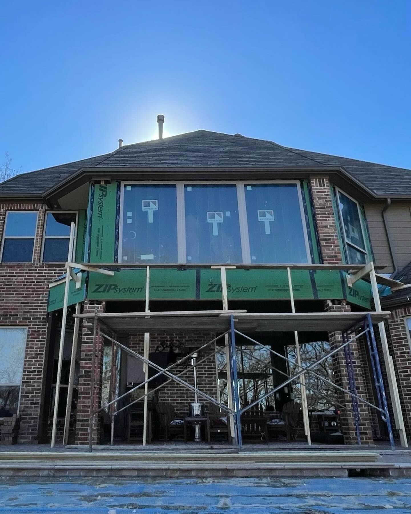The back of a brick house with scaffolding around it.