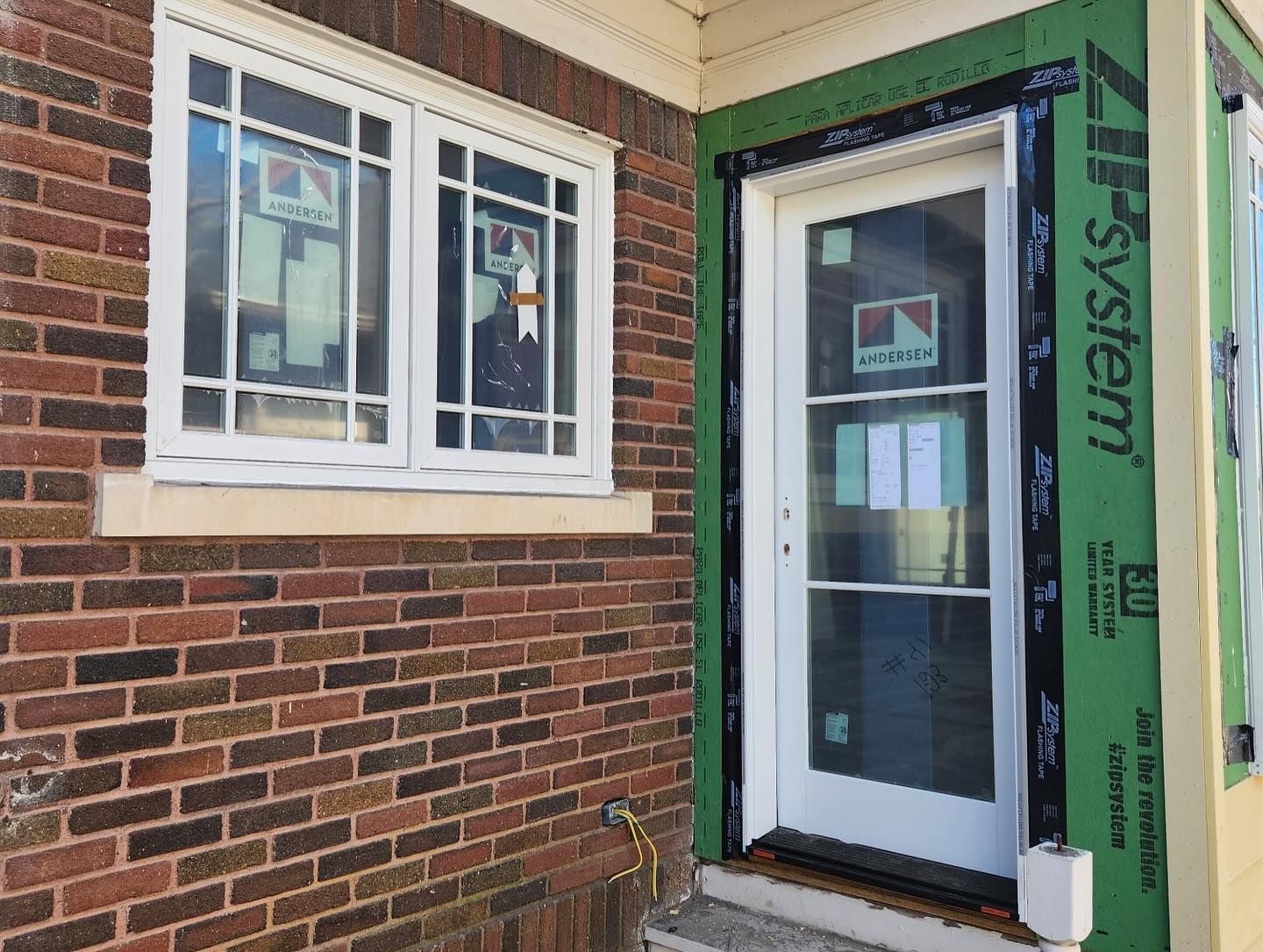 A brick building with a white door and windows.