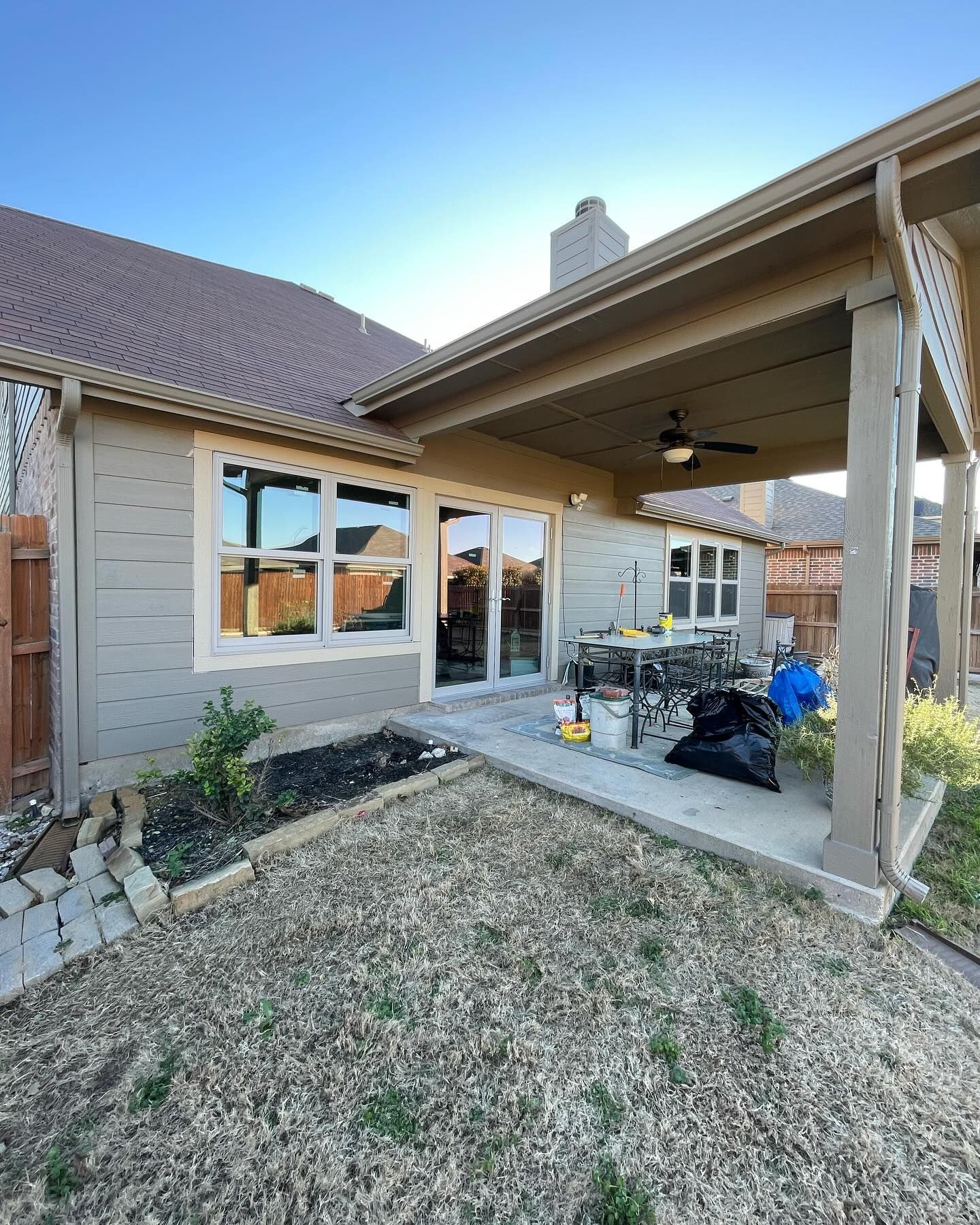 A house with a covered patio and a lot of windows.