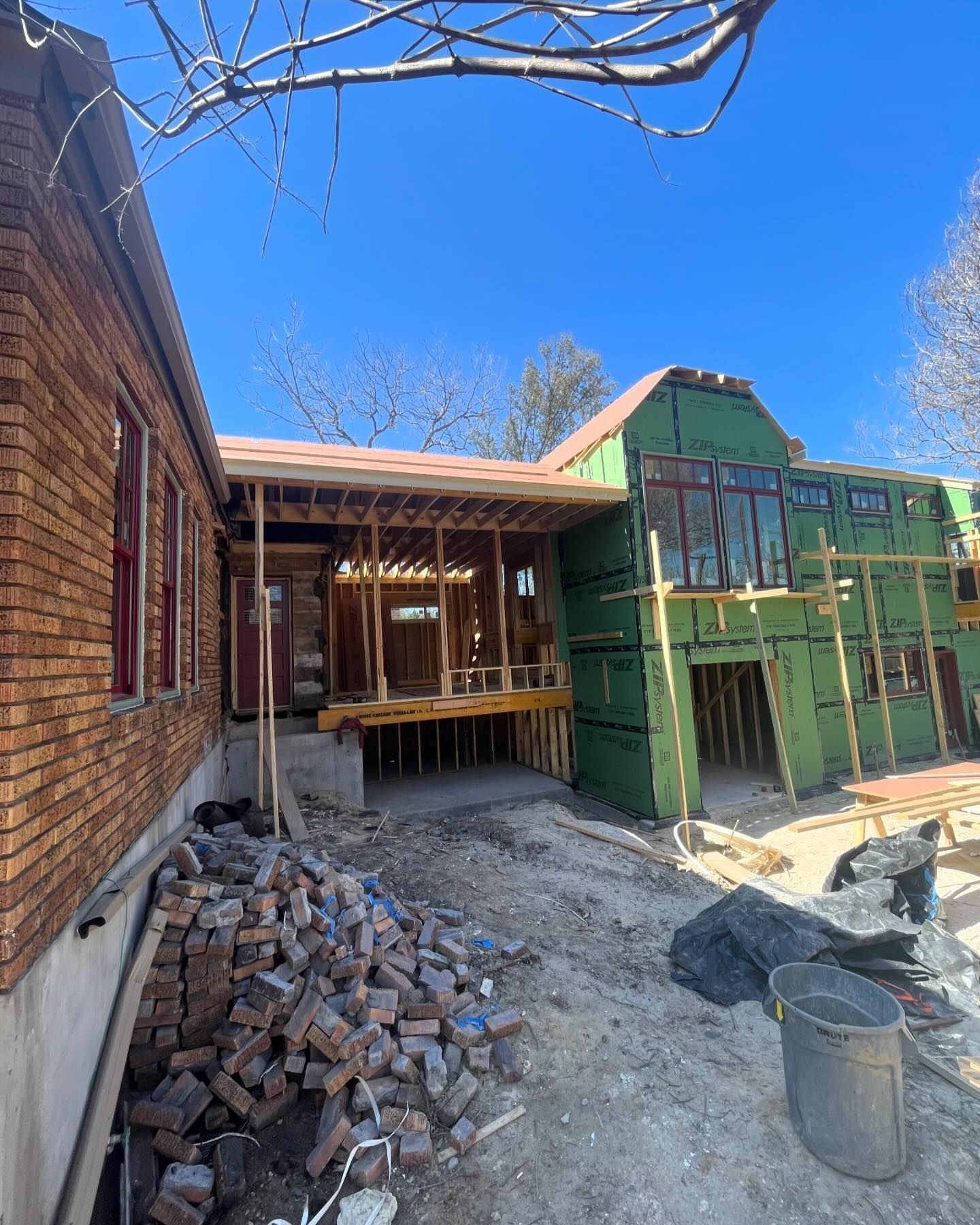 A brick house is being built with a green roof.
