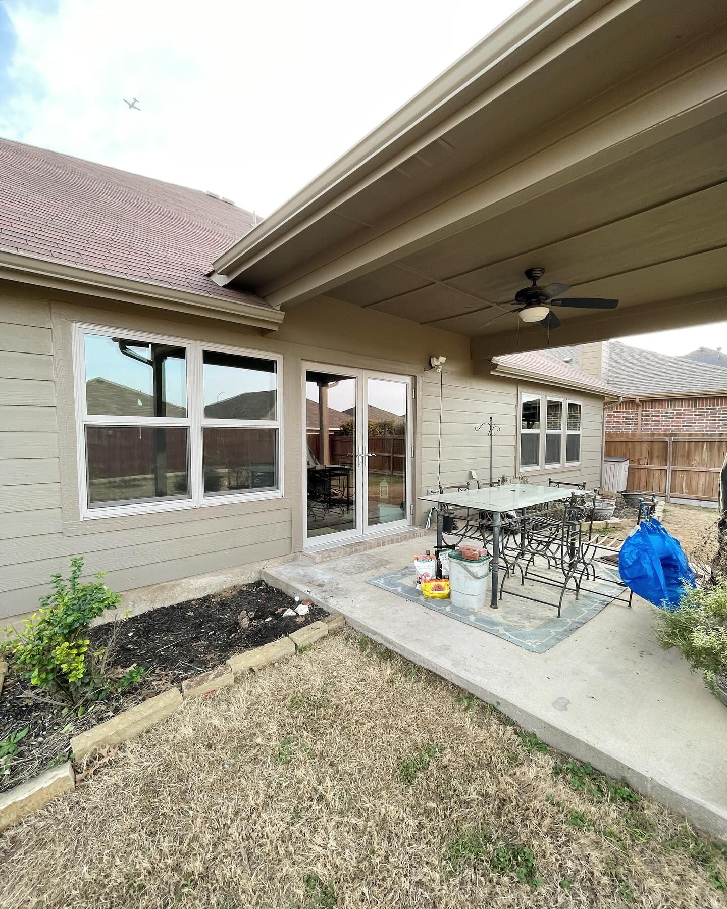 The backyard of a house with a patio and a table and chairs.