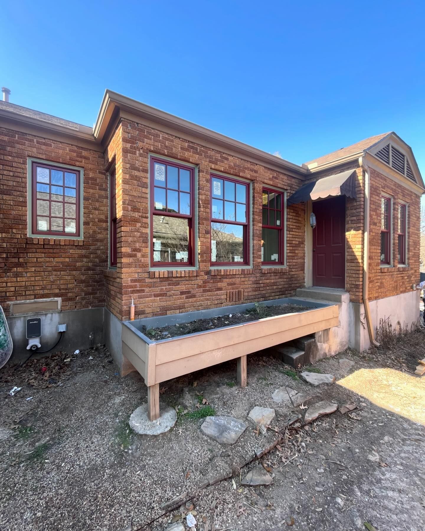 A brick house with a wooden planter in front of it.