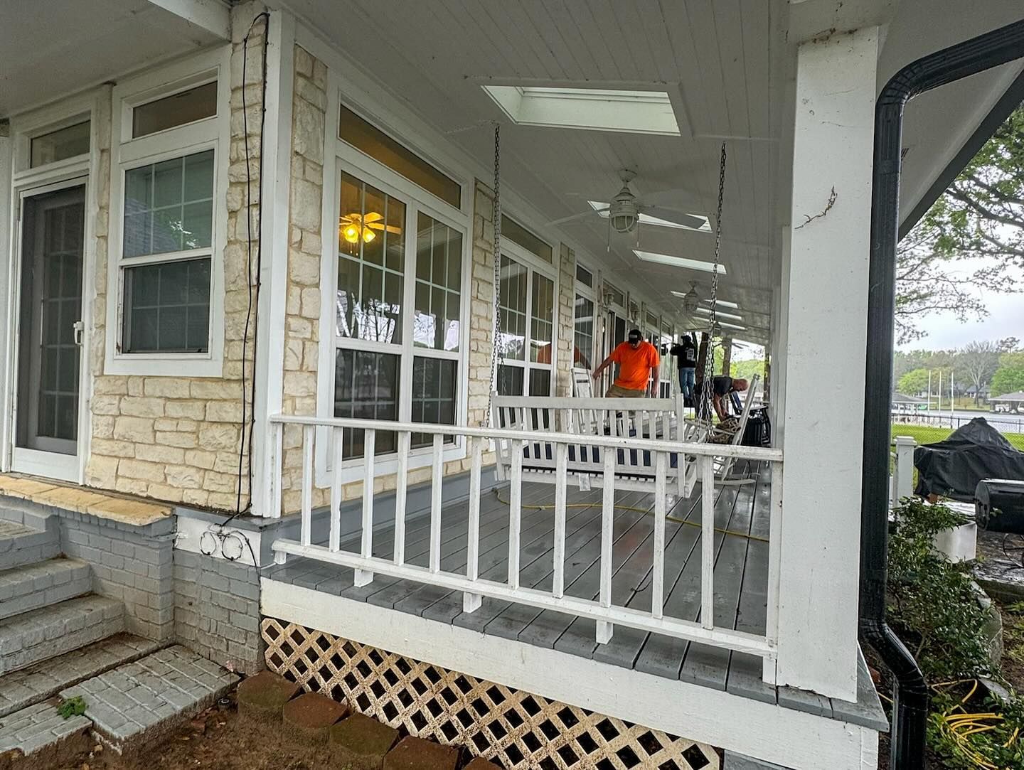 A group of people are sitting on a porch of a house.