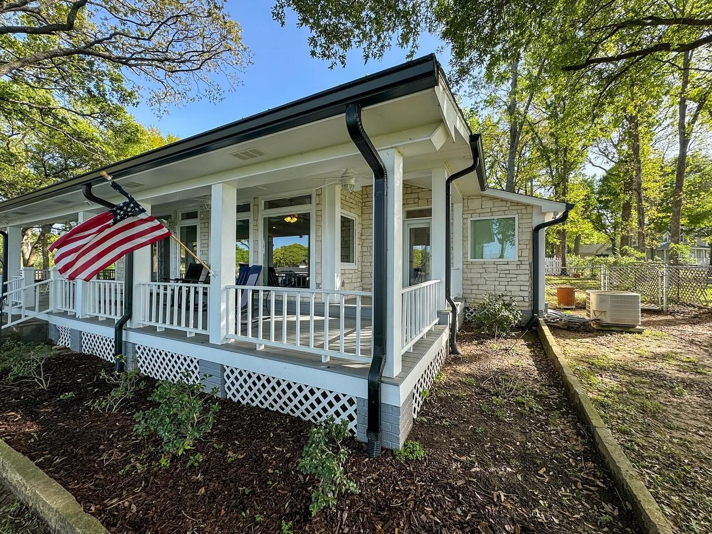 A house with a porch and an american flag on it.