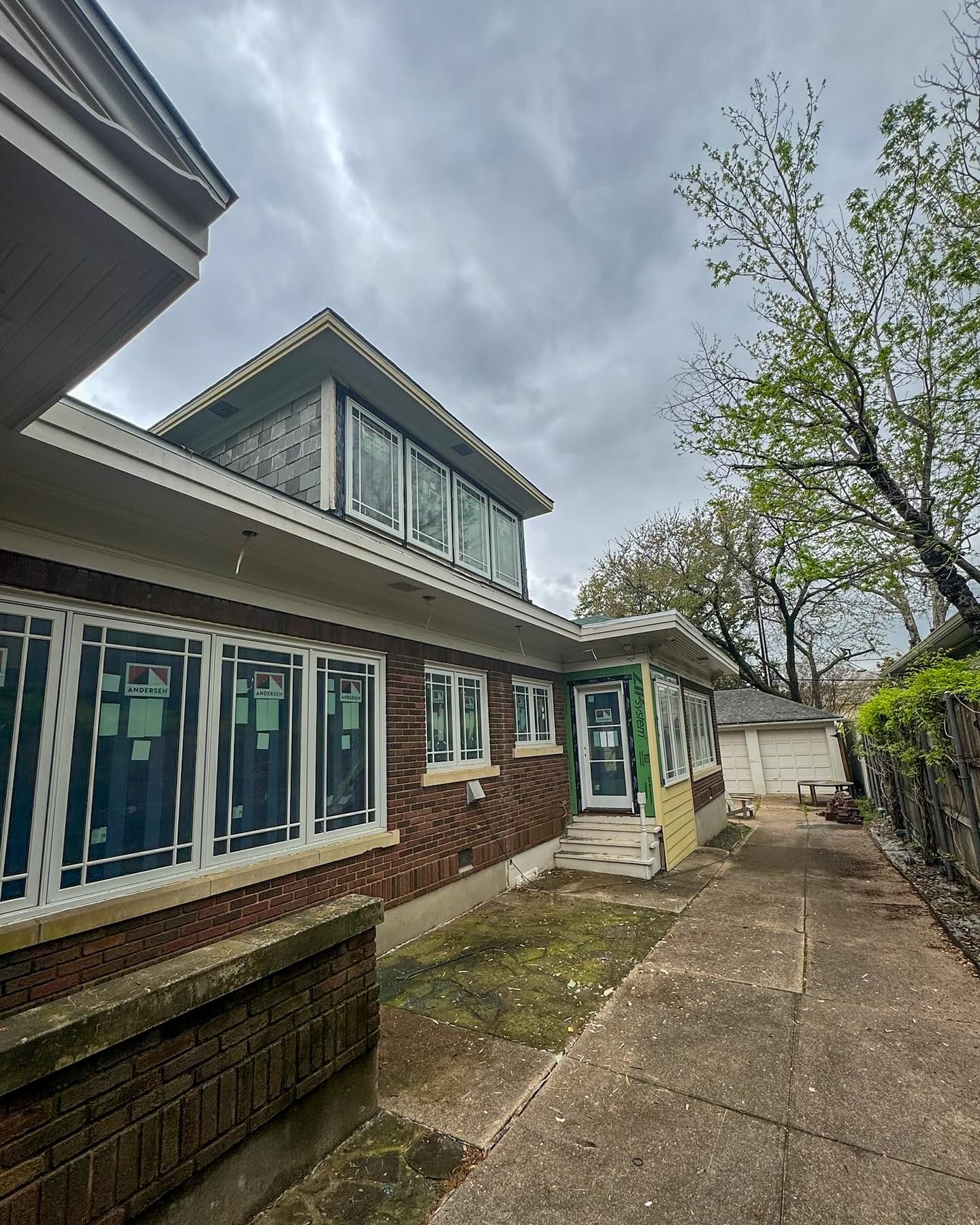 A large brick house with a lot of windows and a walkway leading to it.