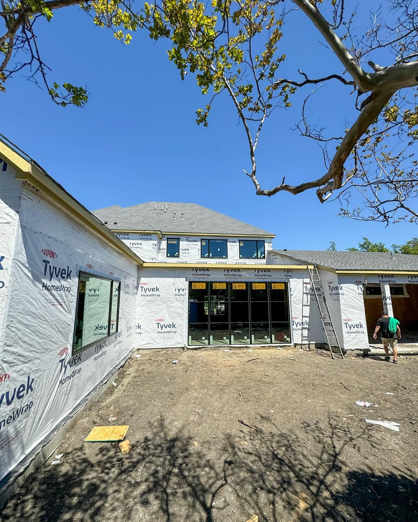 A man is standing in front of a house that is being built.