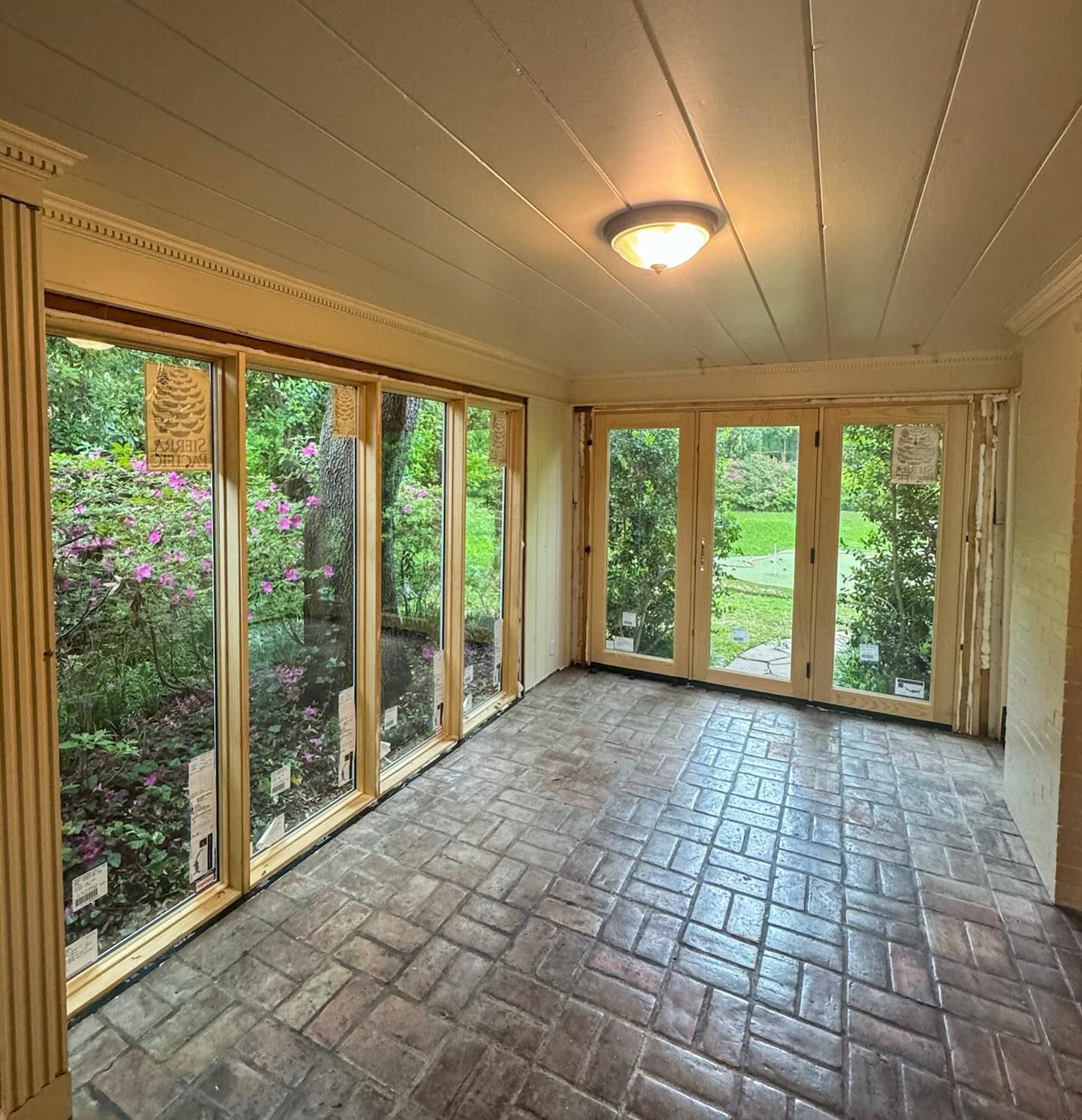 A room with a lot of windows and a brick floor