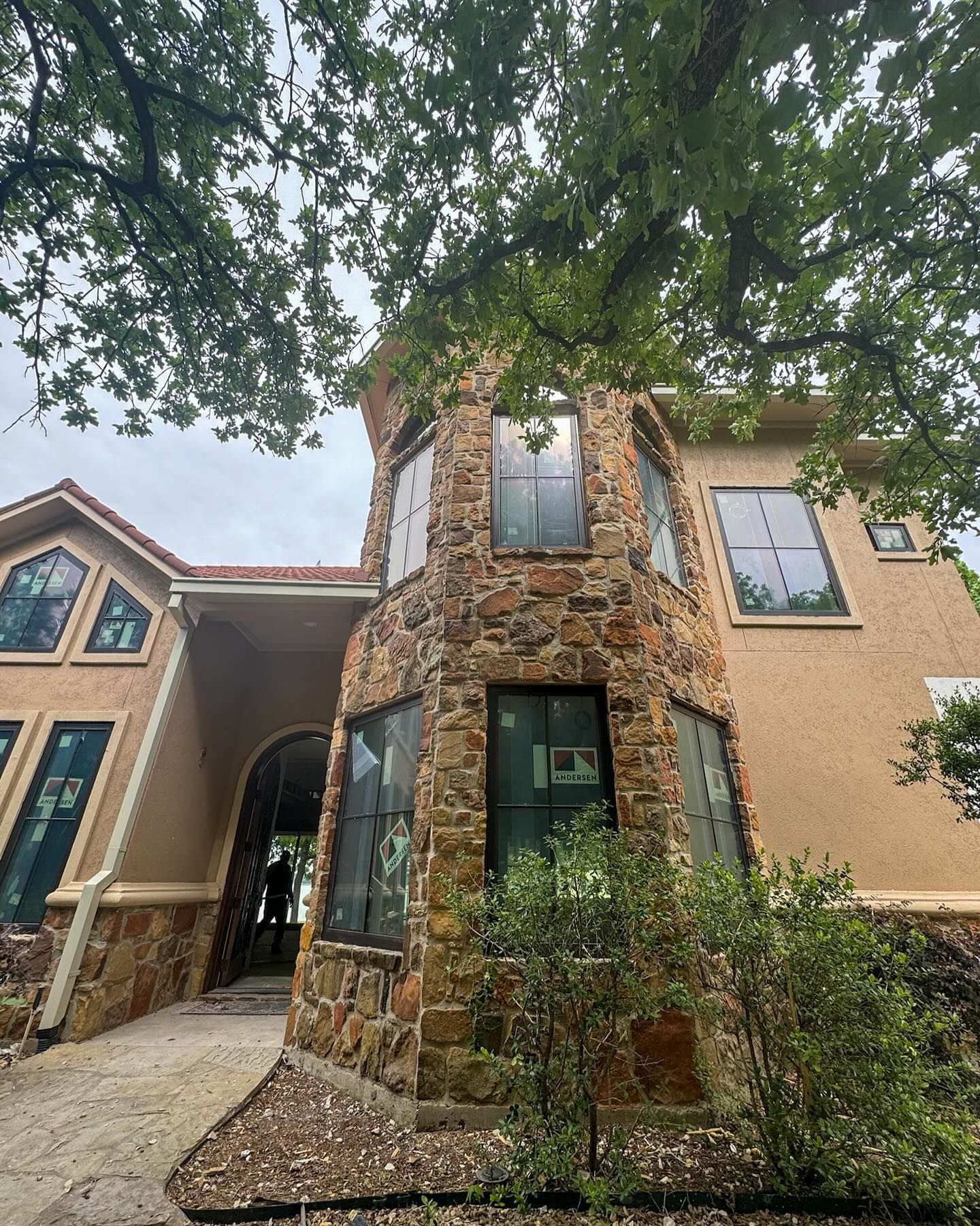 A large house with a lot of windows and a tree in front of it.