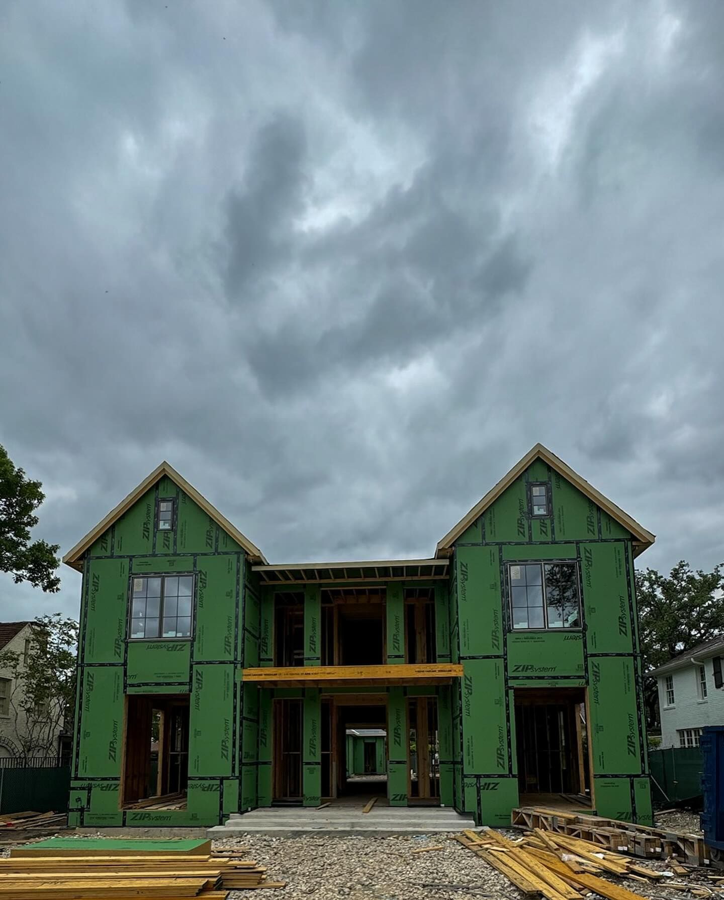 A house under construction with a cloudy sky in the background