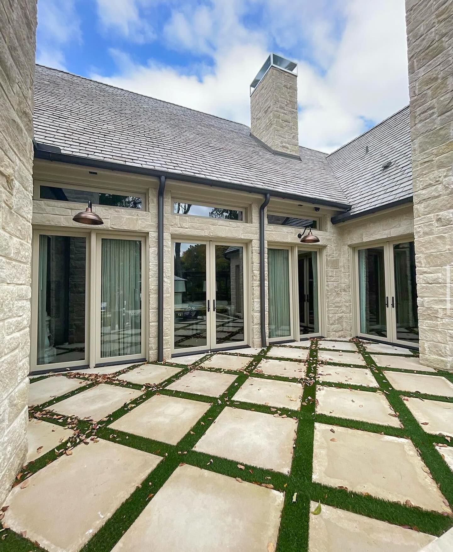 A large house with a lot of windows and sliding glass doors.