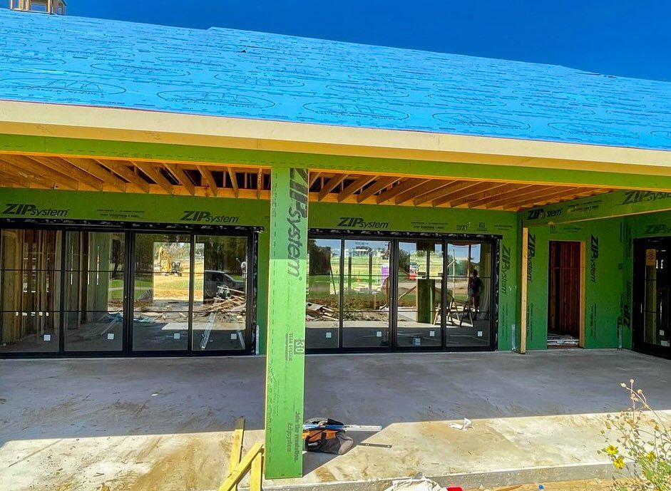 A building under construction with a blue roof and a lot of windows.