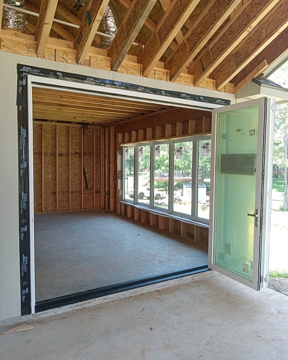 A room with a lot of windows and a door that is open.