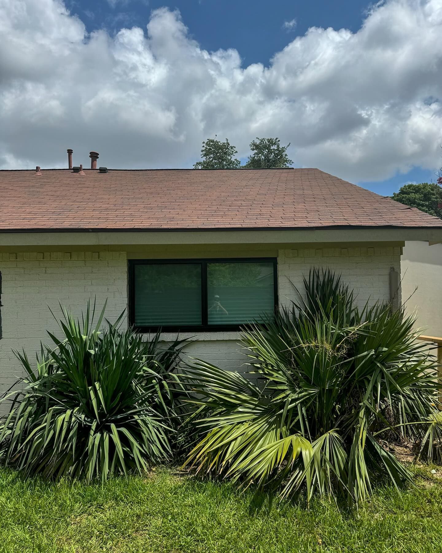 A white house with a brown roof and a window