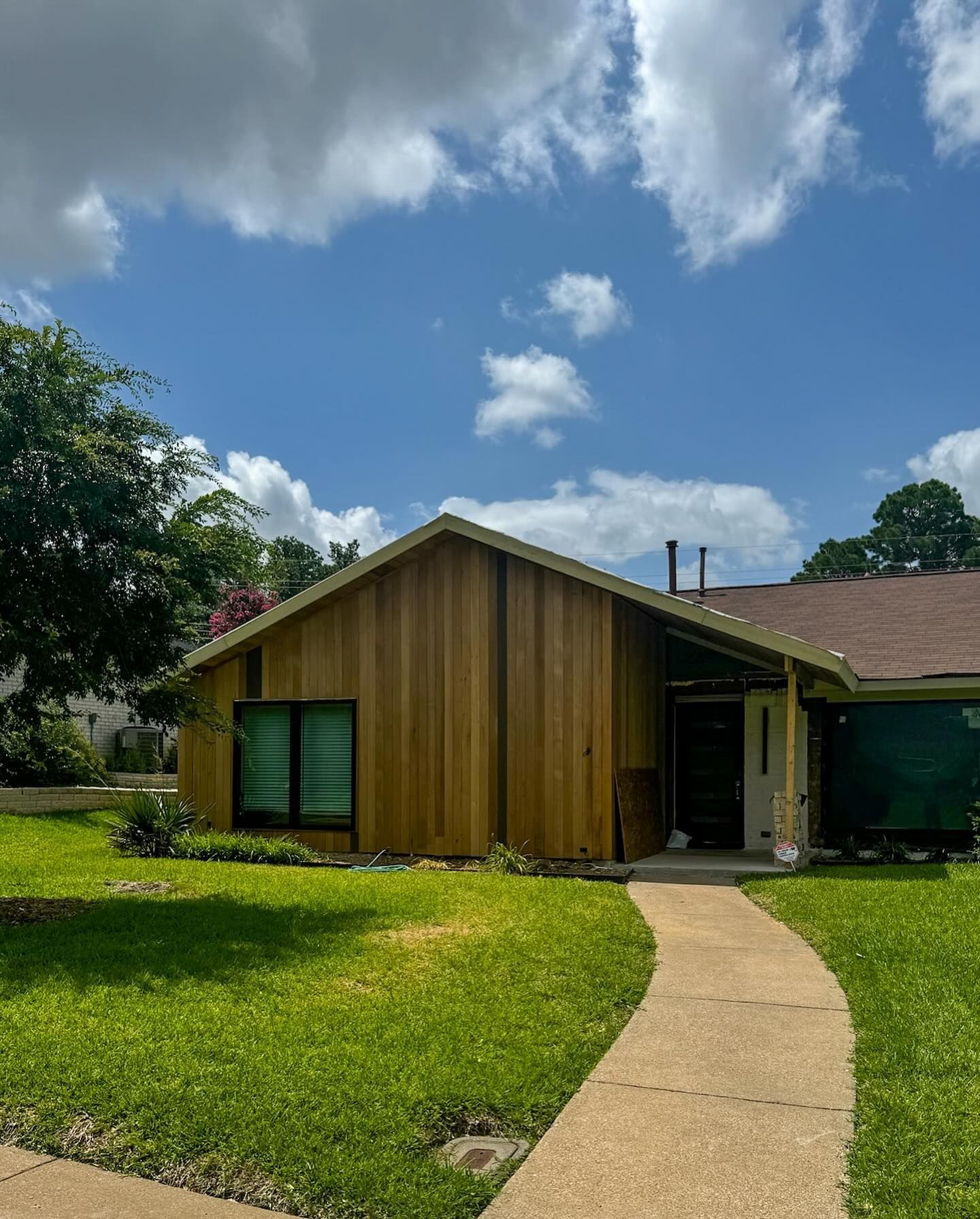 A house with a walkway leading to it on a sunny day