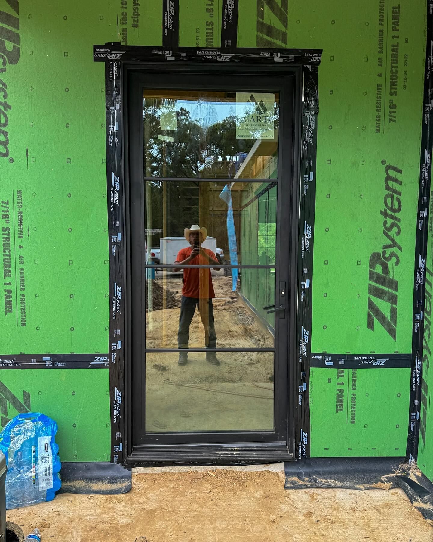 A man taking a picture of himself in front of a door that says zipsystem