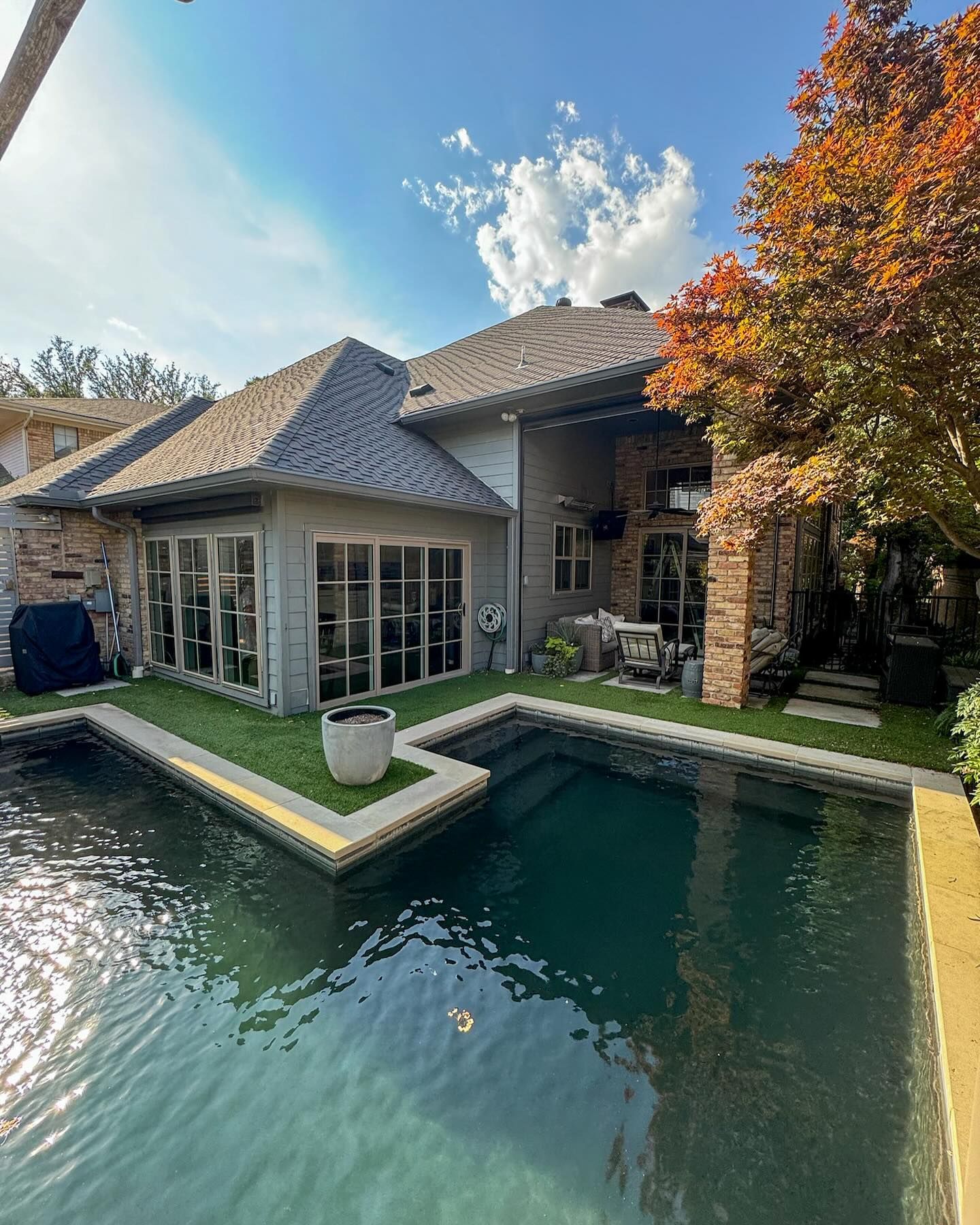 A large house with a large swimming pool in front of it.