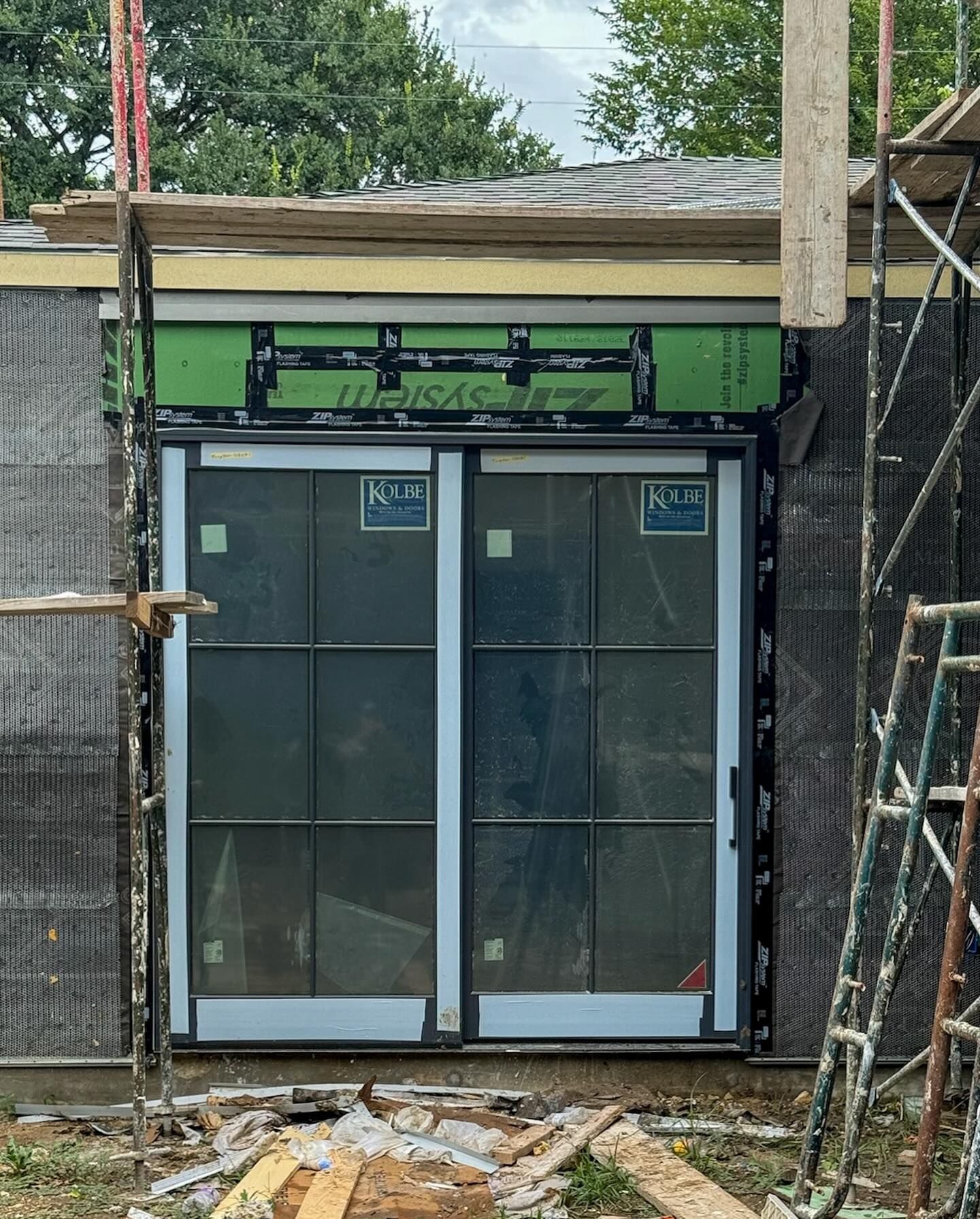 A sliding glass door is being installed on a building under construction.
